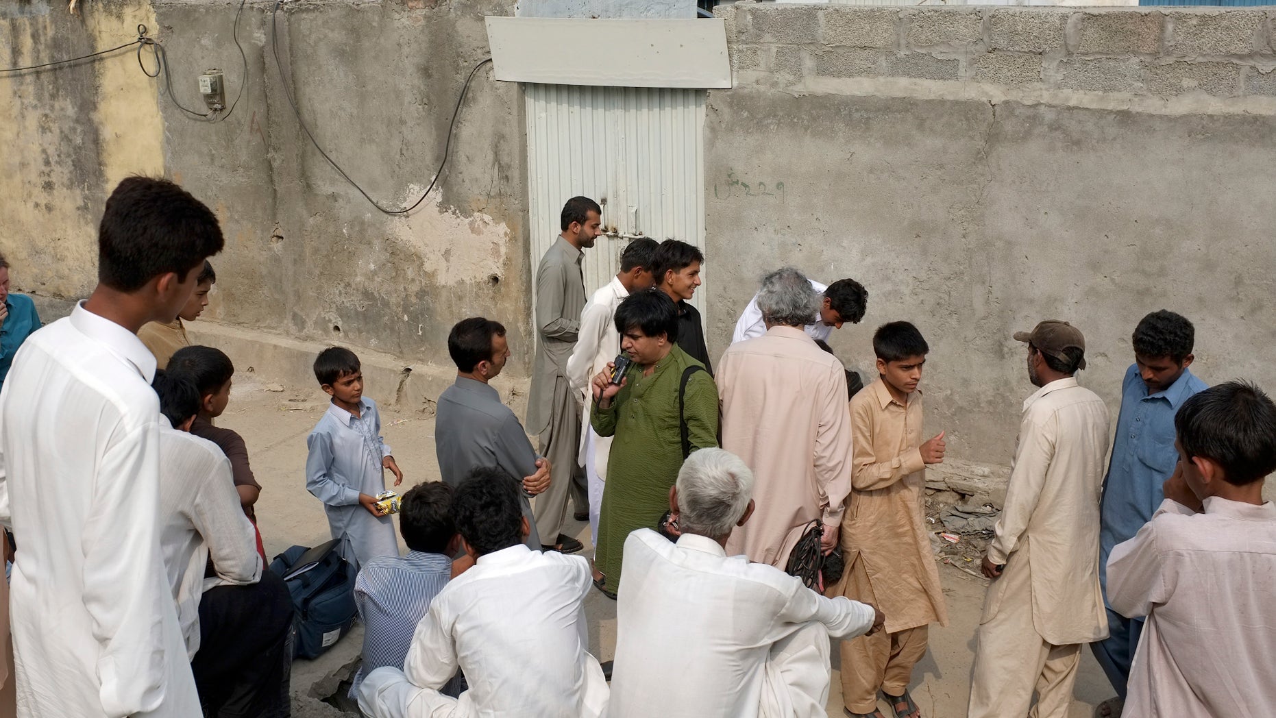 Aug. 20- People gathered outside the locked house of a Christian girl in suburbs of Islamabad, Pakistan. Pakistani authorities arrested a Christian girl and are investigating whether she violated the country's strict blasphemy laws.