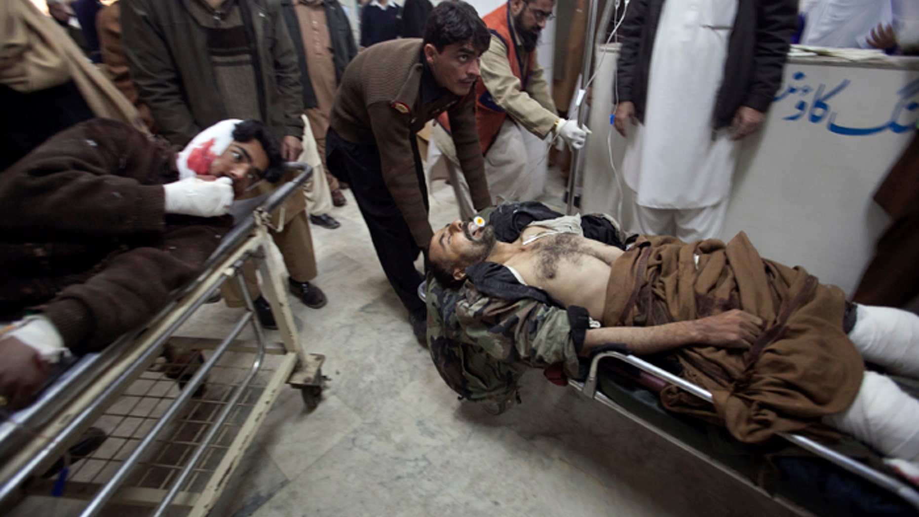 Dec. 25, 2010: Men injured in a suicide bomb attack in Pakistan's northwest Bajaur region are brought to Lady Reading Hospital in Peshawar for treatment. A burqa-clad bomber attacked a crowd of people waiting for aid in Pakistan on Saturday, killing at least 40 of them, officials said, showing militants' ability to strike despite army offensives.