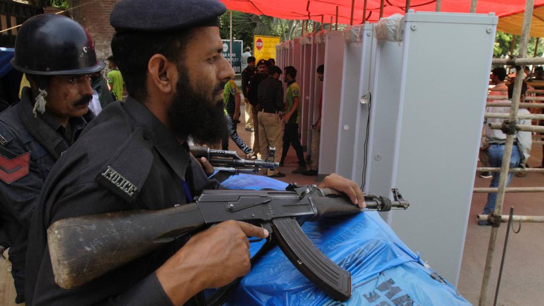 Pakistani police officers stand alert at an entrance of the Gaddafi stadium during the second one-day international match between Pakistan and Zimbabwe Friday, May 29, 2015. Zimbabwe is the first test playing nation to visit Pakistan in more than six years since gunmen attacked a bus of the Sri Lanka team in Lahore in 2009. (AP Photo/K.M. Chaudary)