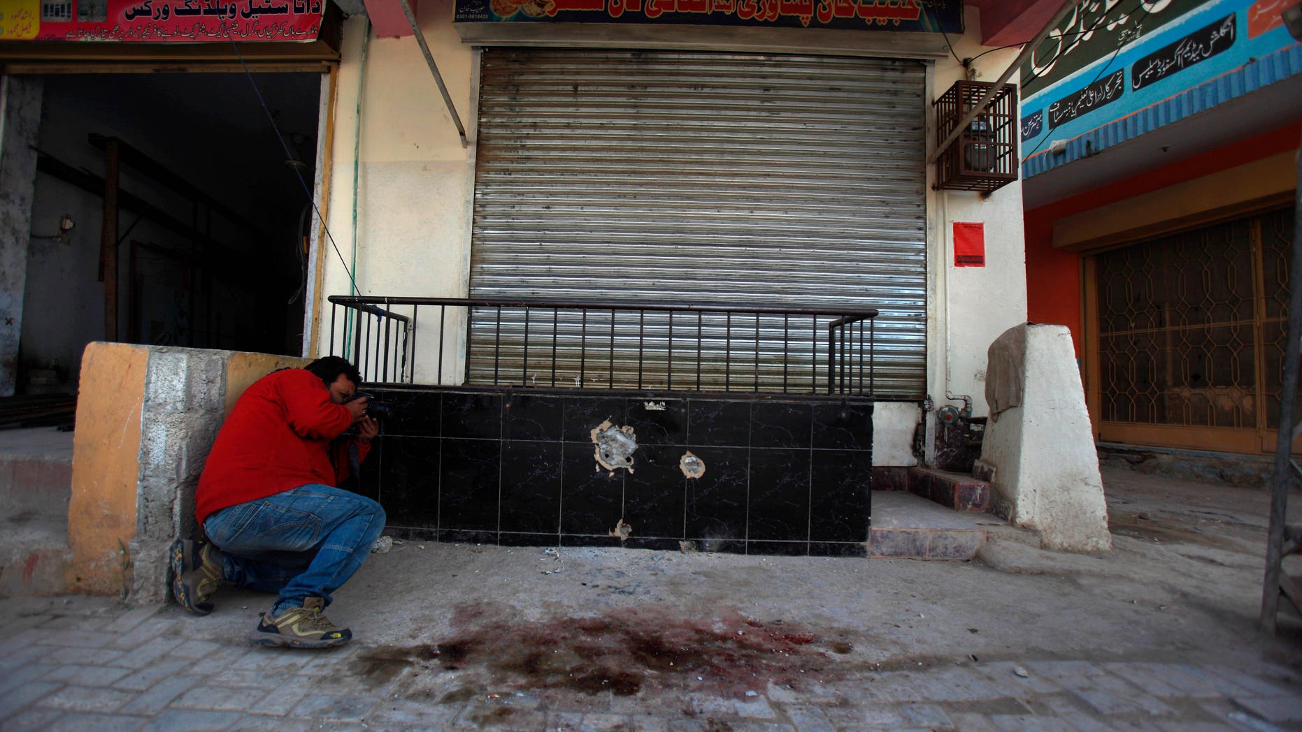 Nov. 11, 2013 - A photographer takes picture of the spot where Nasiruddin Haqqani, a senior leader of the feared militant Haqqani network, was assassinated at an Afghan bakery in the Bhara Kahu area on the outskirts of Islamabad, Pakistan.