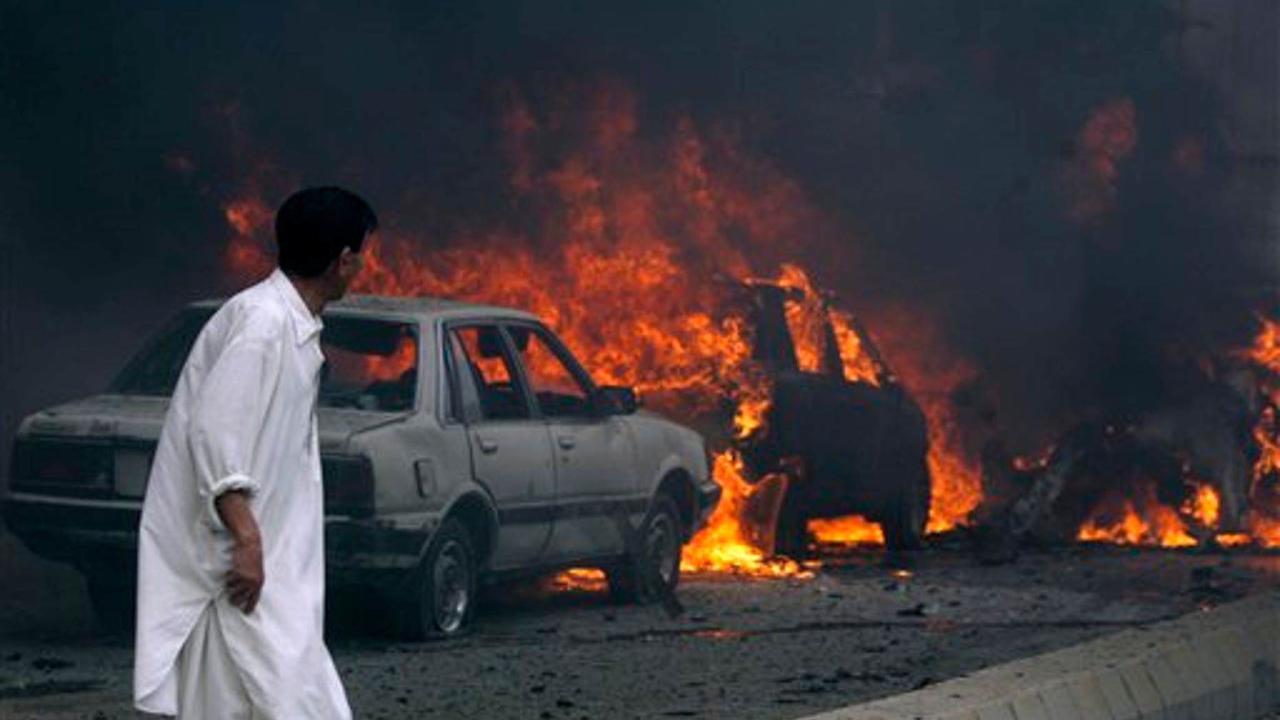 August 31: A Pakistani looks to burning cars after a suicide bombing in Quetta, Pakistan.