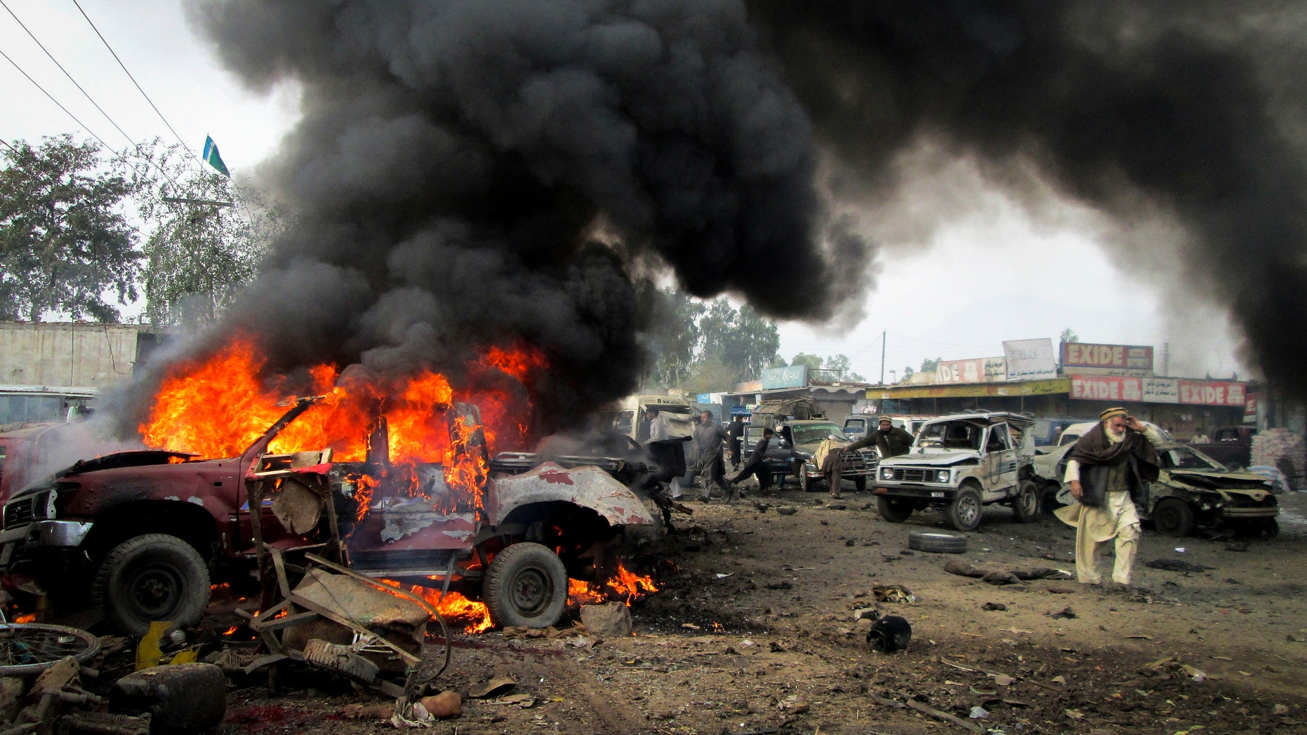 Dec. 17, 2012 - A Pakistani man walks past a burning vehicle after a blast in the Pakistani tribal area of Khyber.
