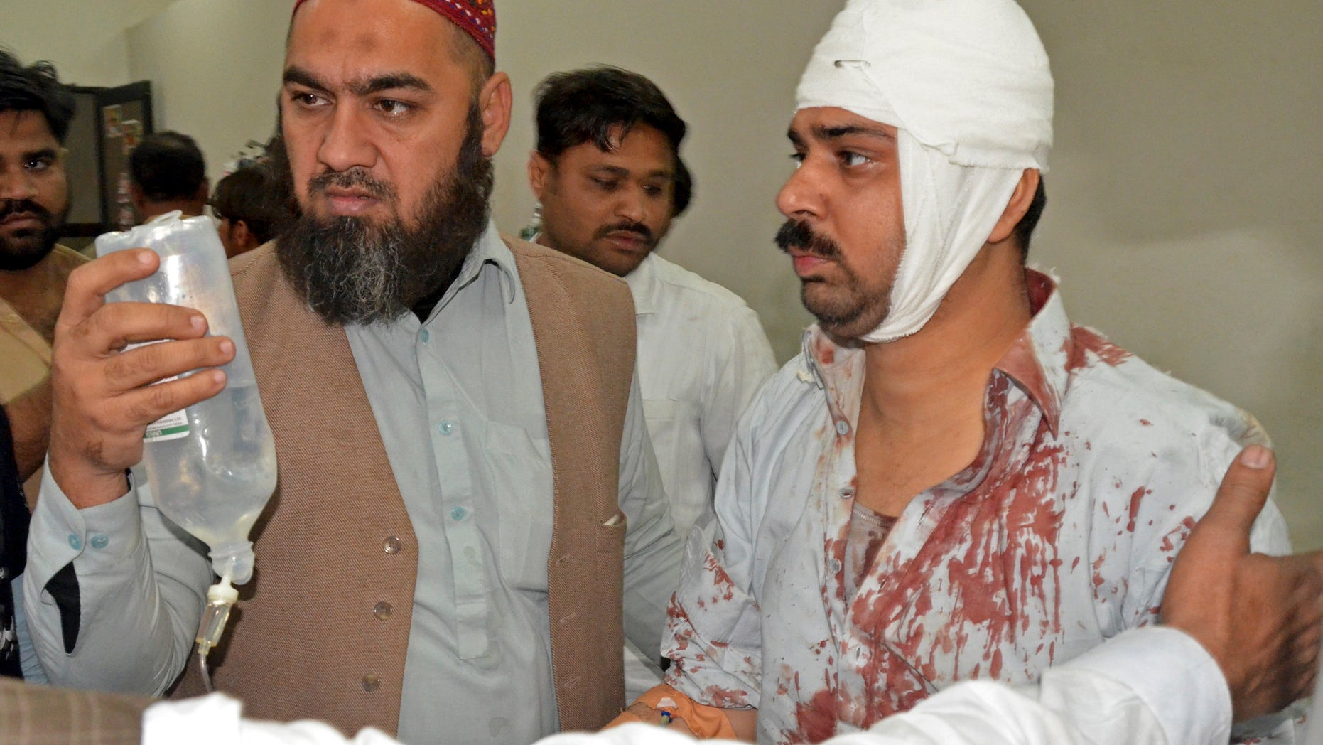 Jan. 30, 2015 - People help a person injured in a bomb blast as he arrives at a local hospital in Shikarpur, Pakistan. A bomb ripped through a mosque in Pakistan belonging to members of the Shiite minority sect of Islam just as worshippers were gathering for Friday prayers, killing dozens of people and wounding many others, officials said.