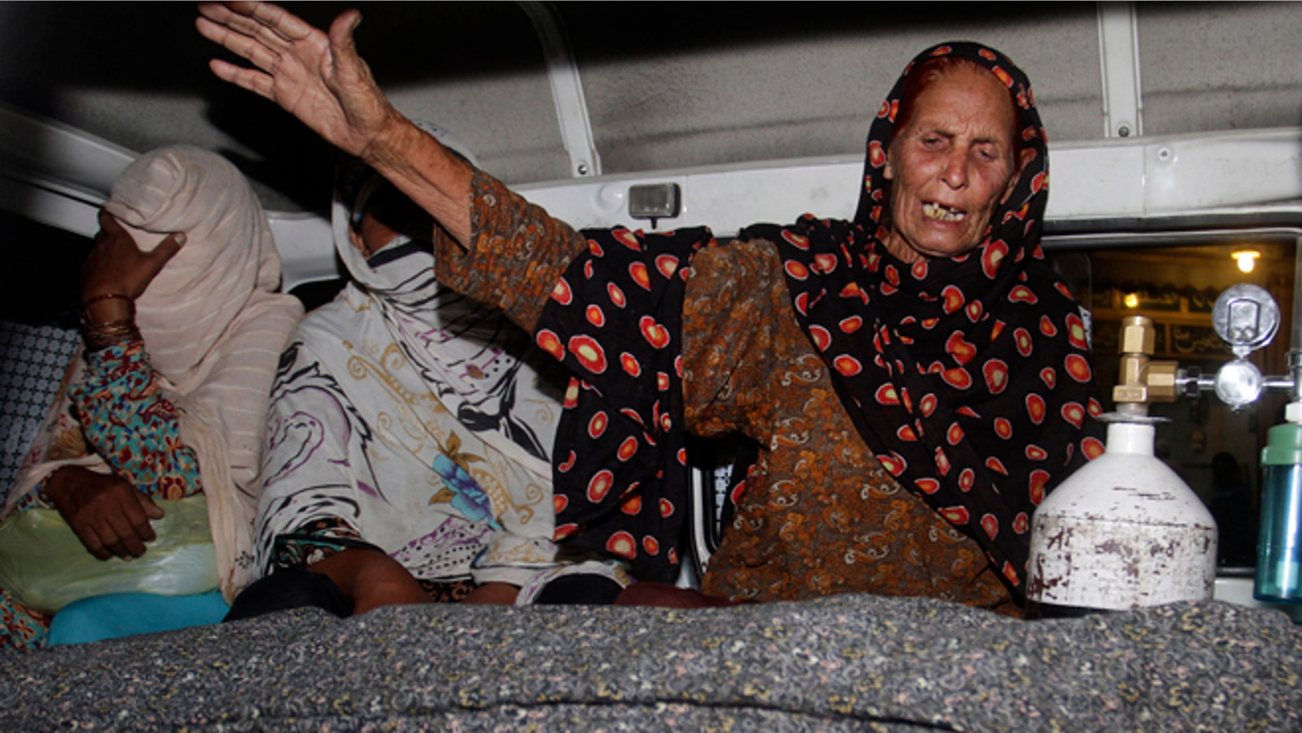 May 27, 2014: A family member of a pregnant woman who was stoned to death by her own family wails over her dead body in an ambulance at a local hospital in Lahore, Pakistan. (AP)