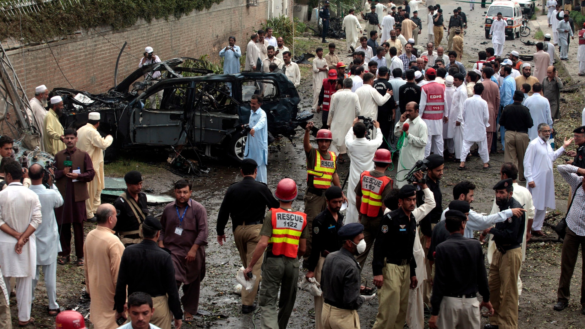 Sept. 3, 2012: Officials and rescue volunteers gather at the bombing site in Peshawar, Pakistan.