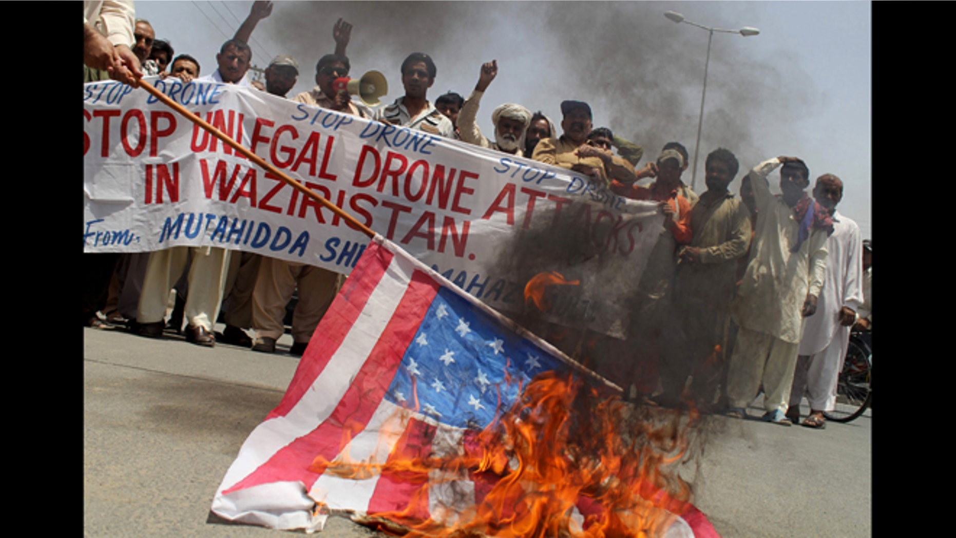 May 30, 2013: Pakistani protesters burn a representation of a U.S. flag to condemn a drone attack in the Pakistani tribal area of Waziristan which killed Taliban leader Waliur Rehman in Multan, Pakistan.
