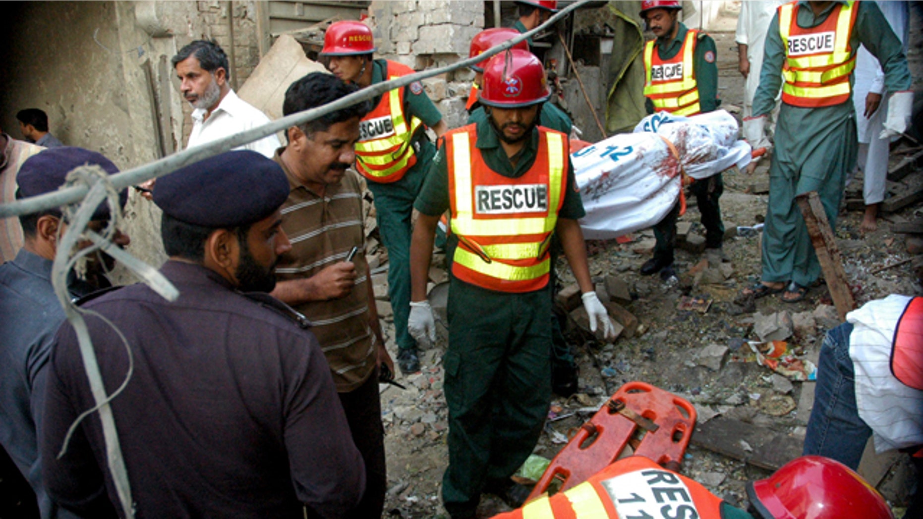 Oct. 25, 2010: In this photo released by China's Xinhua news agency, people gather at the blast site in Pak Pattan, a city in Pakistan's Punjab province, early Monday morning.