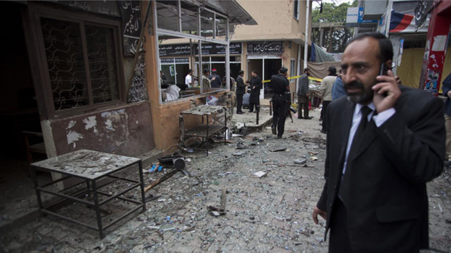 March 3, 2014: A Pakistani lawyer talks on his mobile phone at the site of a suicide attack in a court complex in Islamabad, Pakistan. Two suicide bombers blew themselves up at the complex on Monday, killing 11 people and wounding dozens in a rare terror attack in the heart of Islamabad, officials said. (AP Photo/B.K. Bangash)
