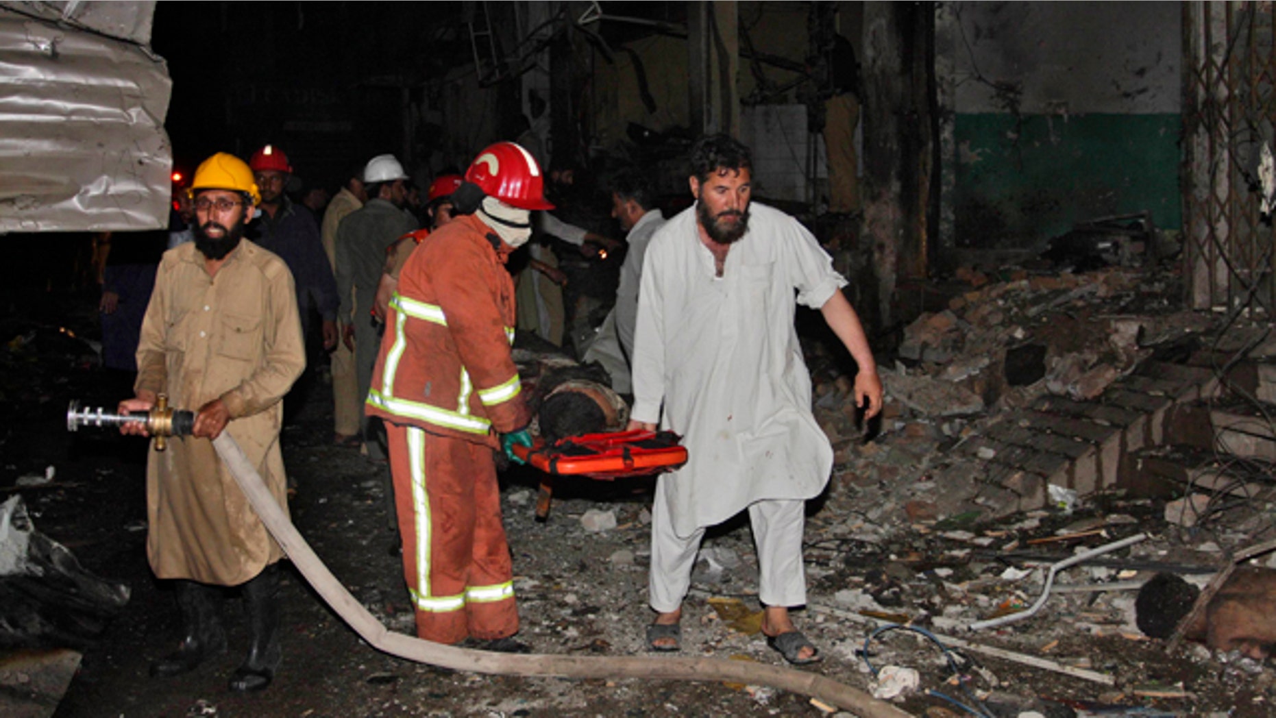 June 12: Pakistani rescue workers carry away a wounded man from the site of an explosion in Peshawar, Pakistan.