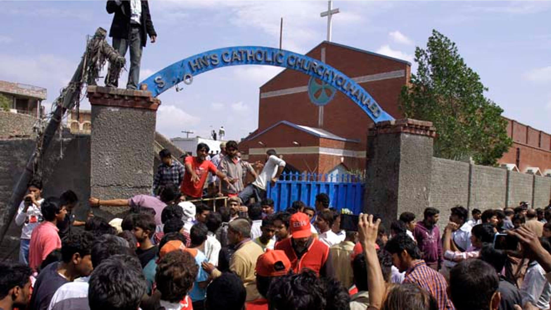March 15, 2015: Pakistani Christians and rescue workers gather outside a church damaged from a suicide bombing attack in Lahore, Pakistan. (AP)