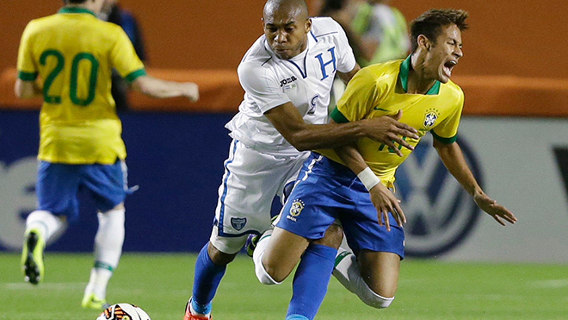 FILE - In this Nov. 16, 2013, file photo, Brazil forward Neymar, foreground, goes down as he battles for the ball with Honduras midfielder Wilson Palacios during the first half of an international friendly soccer game, in Miami Gardens, Fla. Palacios received a yellow card warning on the play. This is the third time in its history that Honduras qualifies for a World Cup. (AP Photo/Wilfredo Lee, File)