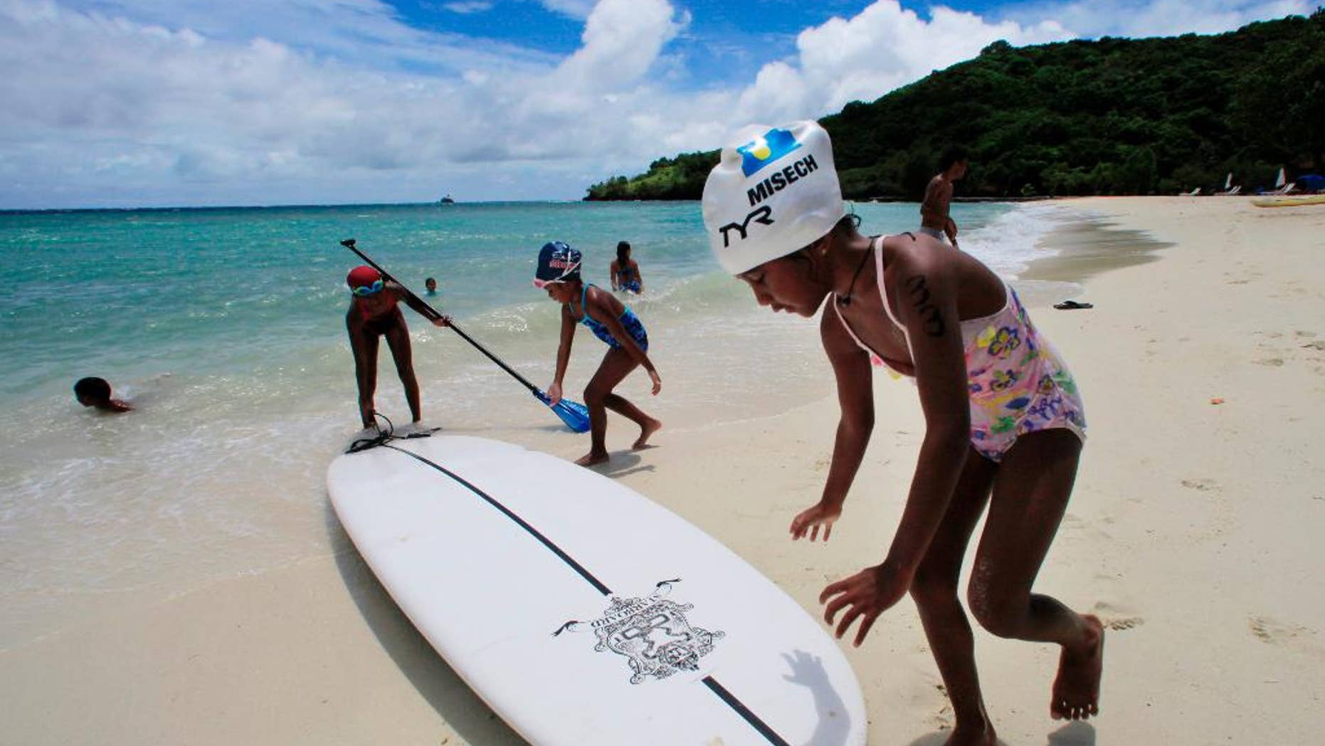 FILE - In this June 13, 2009 file photo, children play at a resort beach in Ngerkebesang, Palau. Lawmakers in the tiny Pacific island nation of Palau passed a law Thursday, Oct. 22, 2015 to make almost all its coastal waters a marine sanctuary in the latest move to expand ocean protections. A news release said Palau's president plans to sign the legislation next week. Friday is a national holiday in Palau. (AP Photo/Itsuo Inouye, File)