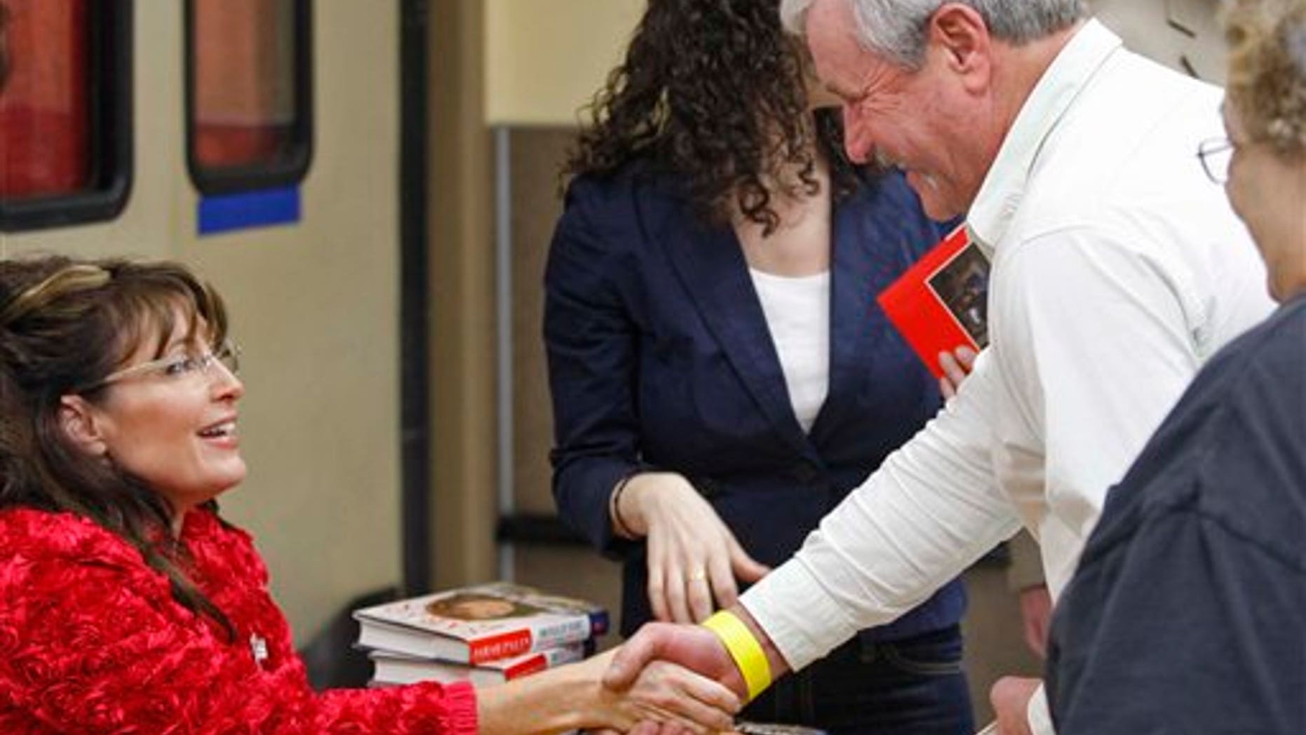 Sarah Palin shakes hands while signing books inside the Walmart in Spirit Lake, Iowa, Thursday, Dec. 2, 2010. (AP Photo/The Register, John Gaps III)