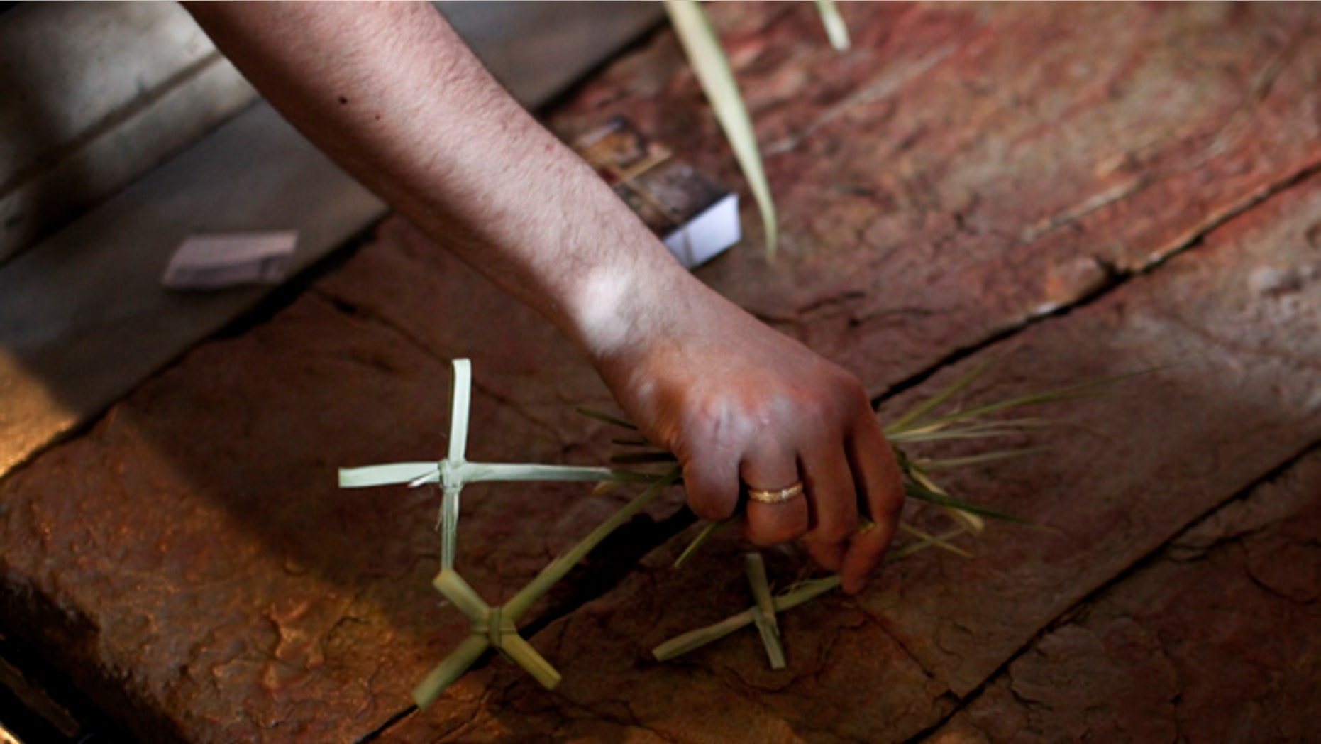 April 17, 2011: A Christian pilgrim places crosses made of palm fronds on the Anointing Stone inside the Church of the Holy Sepulcher, the site where many Christians believe Jesus was crucified and buried, in Jerusalem's Old City.