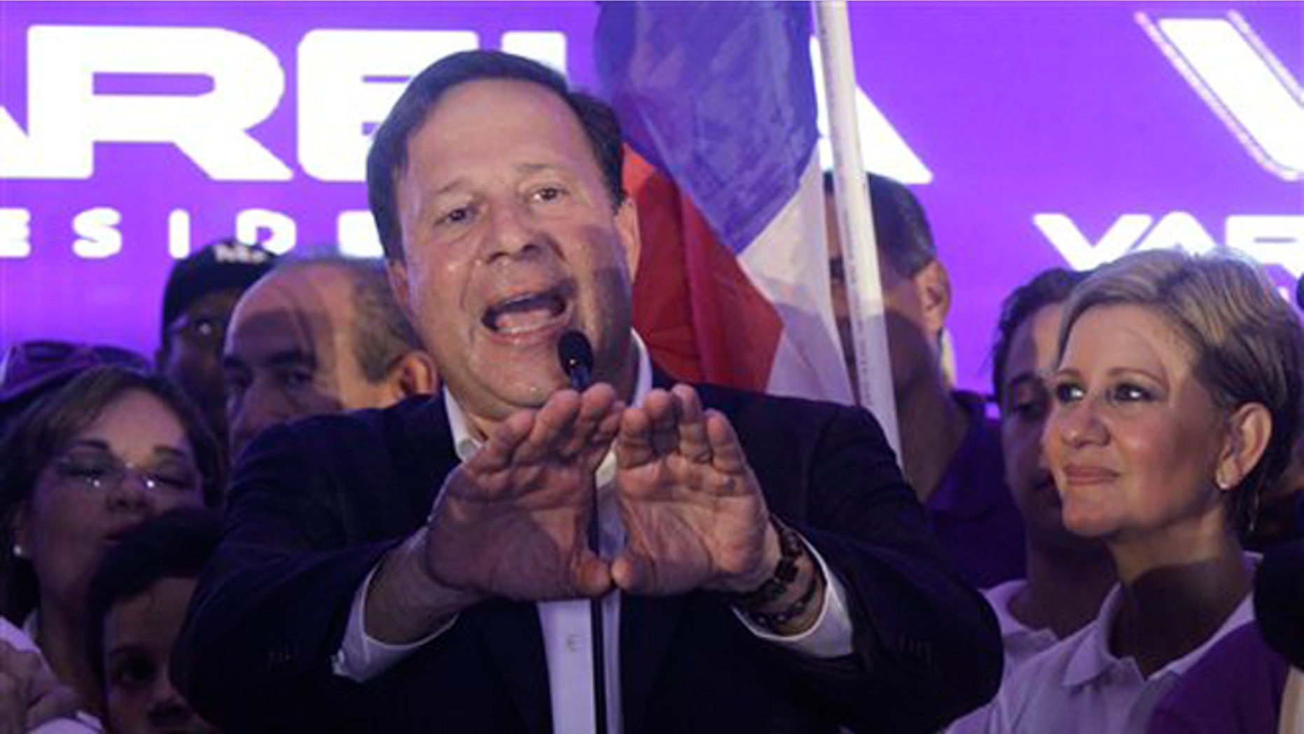 Juan Carlos Varela, Panama's president elect, delivers his acceptance speech as his wife Lorena Castillo, right, looks on in Panama City, Sunday, May 4, 2014. Varela was declared the victor of Panama's presidential election, thwarting an attempt by former ally President Ricardo Martinelli to extend his grip on power by electing a hand-picked successor. (AP Photo/Arnulfo Franco)