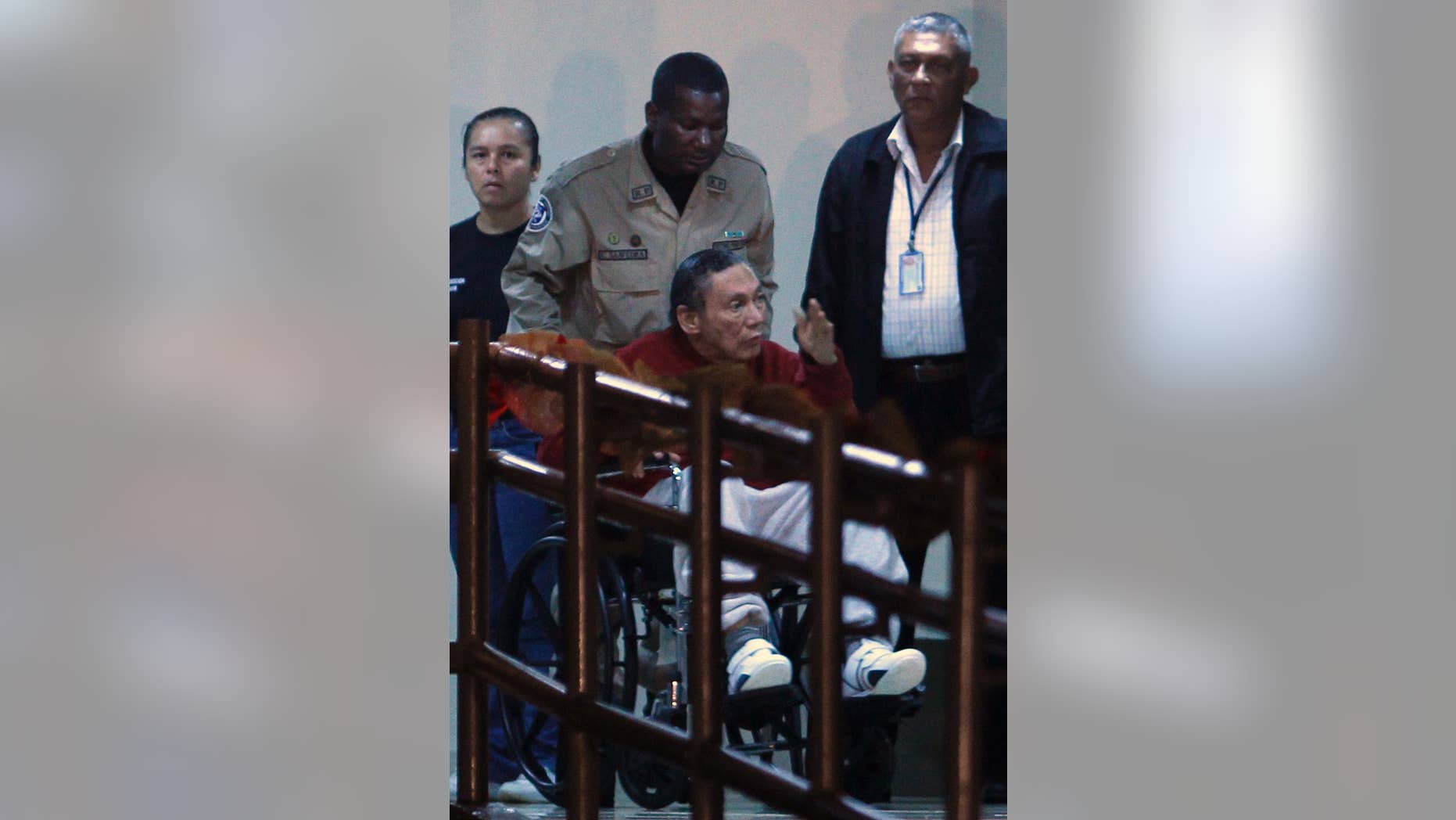 FILE - In this Dec. 11, 2011, file photo, Panama's ex-dictator Manuel Noriega gestures while being carried in a wheelchair by a police officer inside El Renacer prison in the outskirts of Panama City. Speaking to local television network the former Panamanian strongman broke his long silence in a interview from jail, aired on Wednesday, June 24, 2015, asking his compatriots to forgive actions by the military that culminated in the 1989 American invasion. (AP Photo/Esteban Felix, File)