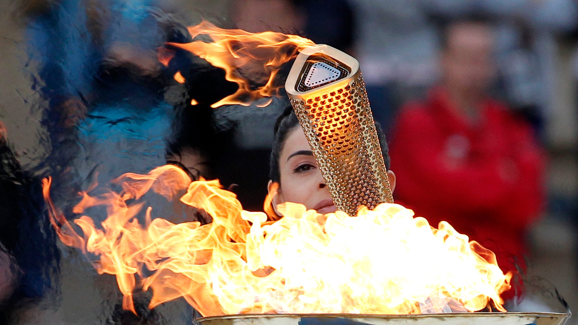 Actress Ino Menegaki, dressed as a high priestess, lights the torch at a ceremony in Panathinean stadium in Athens, Thursday, May 17, 2012. The torch begins its 70-day journey to arrive at the opening ceremony of the London 2012 Olympics, from the Greek capital, to cover about 8,000-mile (12,875-kilometer) on its progress over many parts of England to start the games. (AP Photo/Petros Giannakouris)