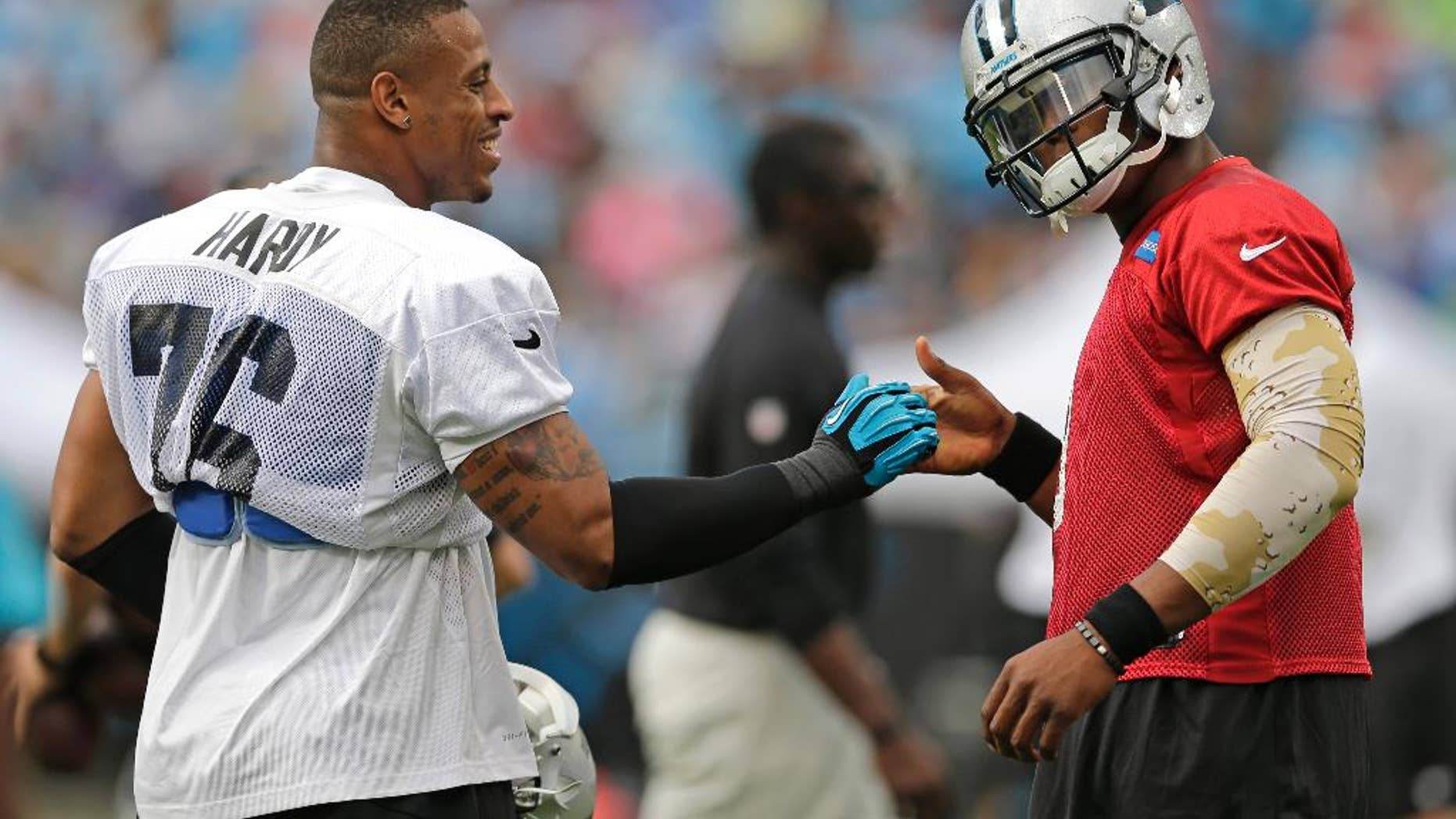 Carolina Panthers' Cam Newton, right, greets Greg Hardy during an NFL football practice at the team's Fan Fest in Charlotte, N.C., Friday, July 25, 2014. (AP Photo)