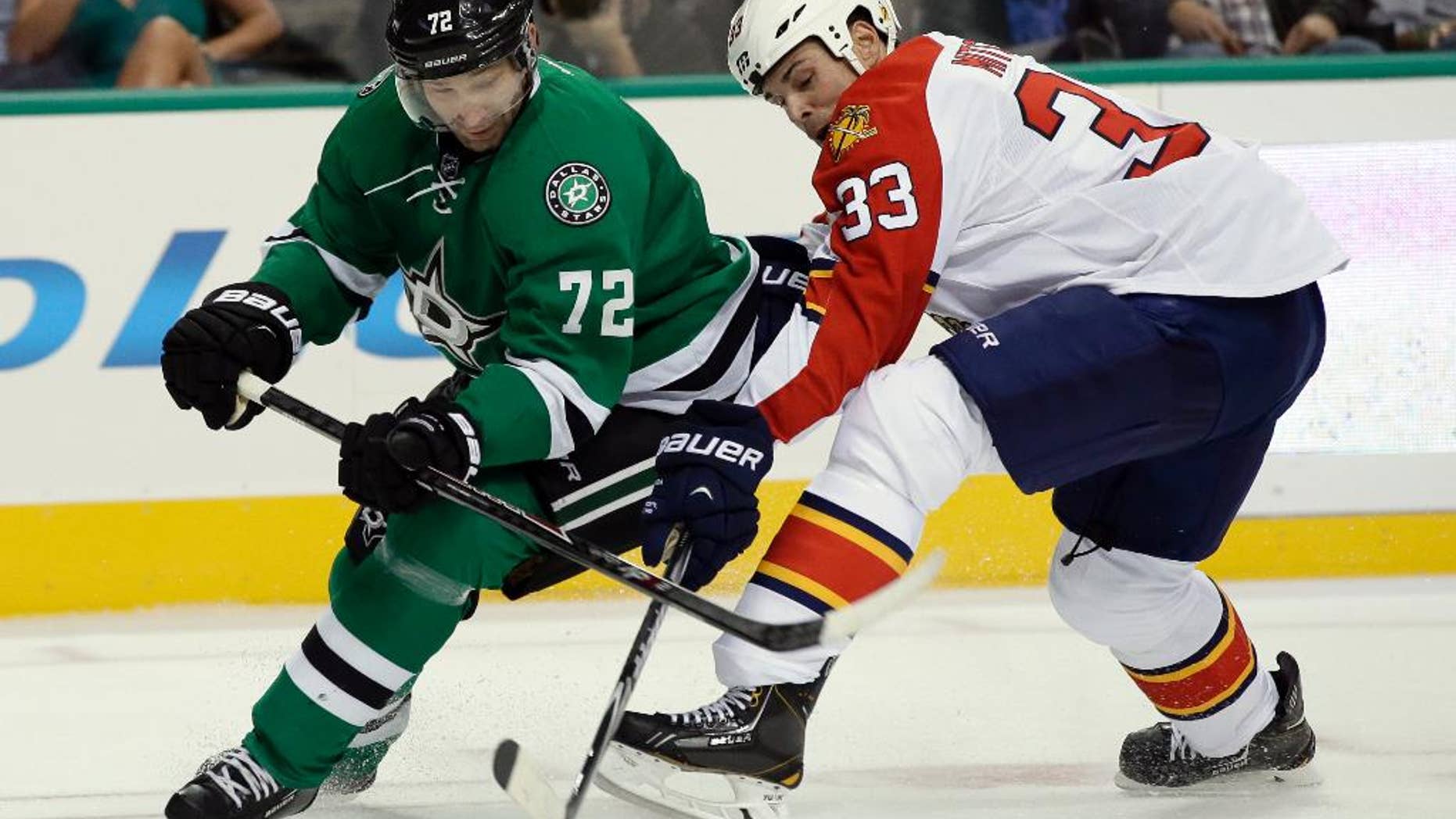 Dallas Stars' Erik Cole (72) and Florida Panthers' Willie Mitchell (33) compete for control of the puck in the first period of an preseason NHL hockey game, Monday, Sept. 29, 2014, in Dallas. (AP Photo/Tony Gutierrez)