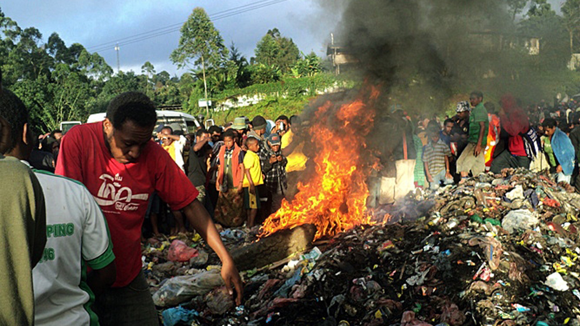 Feb. 6, 2013 - FILE photo, bystanders watch as a woman accused of witchcraft is burned alive in the Western Highlands provincial capital of Mount Hagen in Papua New Guinea.