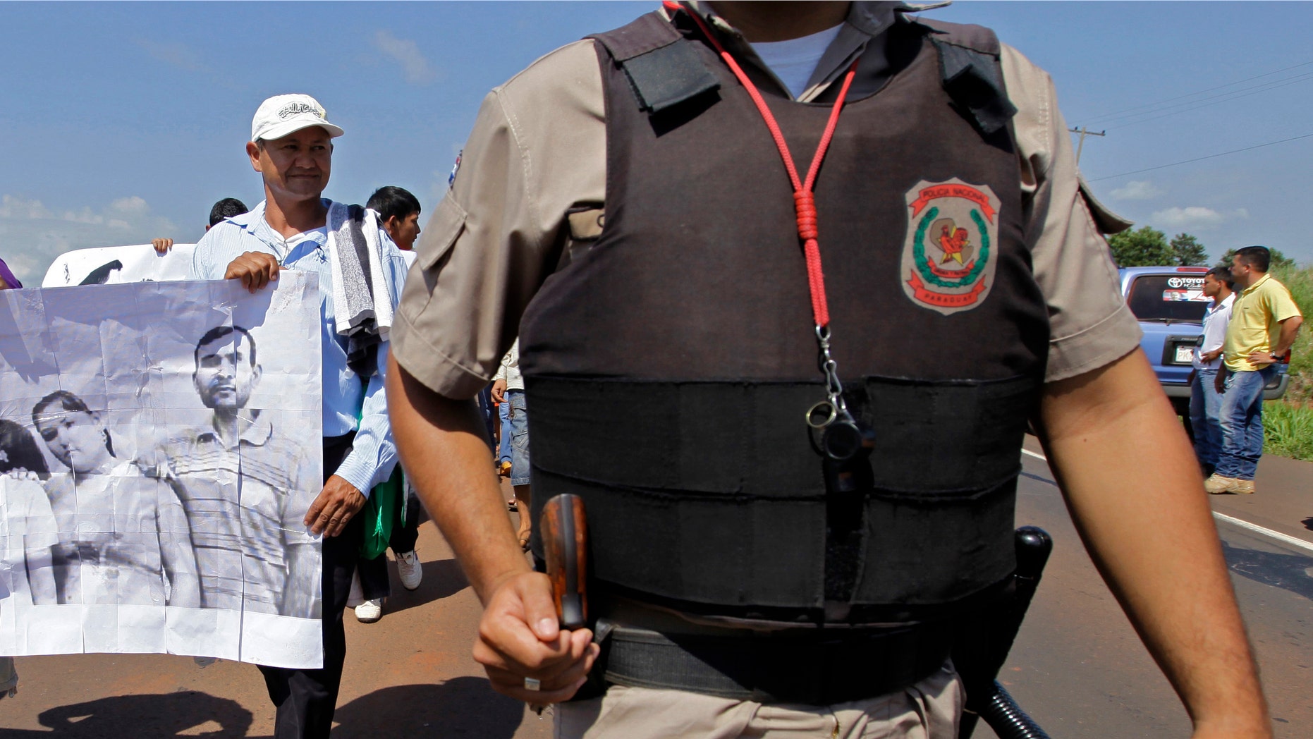 In this photo taken Nov. 15 2012 Vidal Vega, left, holds a banner during a march to demand the freedom of landless farmers near Curuguaty city, Paraguay. (AP Photo/Jorge Saenz)