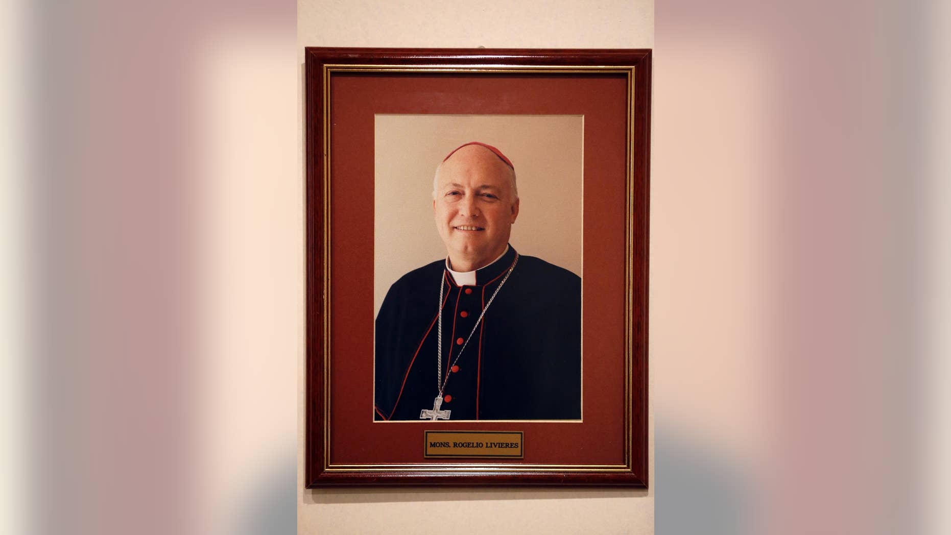 FILE - This May 13, 2015 file photo shows a framed portrait of the ousted Bishop Rogelio Livieres Plano, that hangs on an office wall in Paraguay's Ciudad del Este diocese. The former Paraguayan bishop who was ousted by Pope Francis amid several controversies in his diocese has died of problems related to diabetes in a Buenos Aires hospital, Friday, Aug. 14, 2015. Livieres Plano was 69. (AP Photo/Jorge Saenz, File)