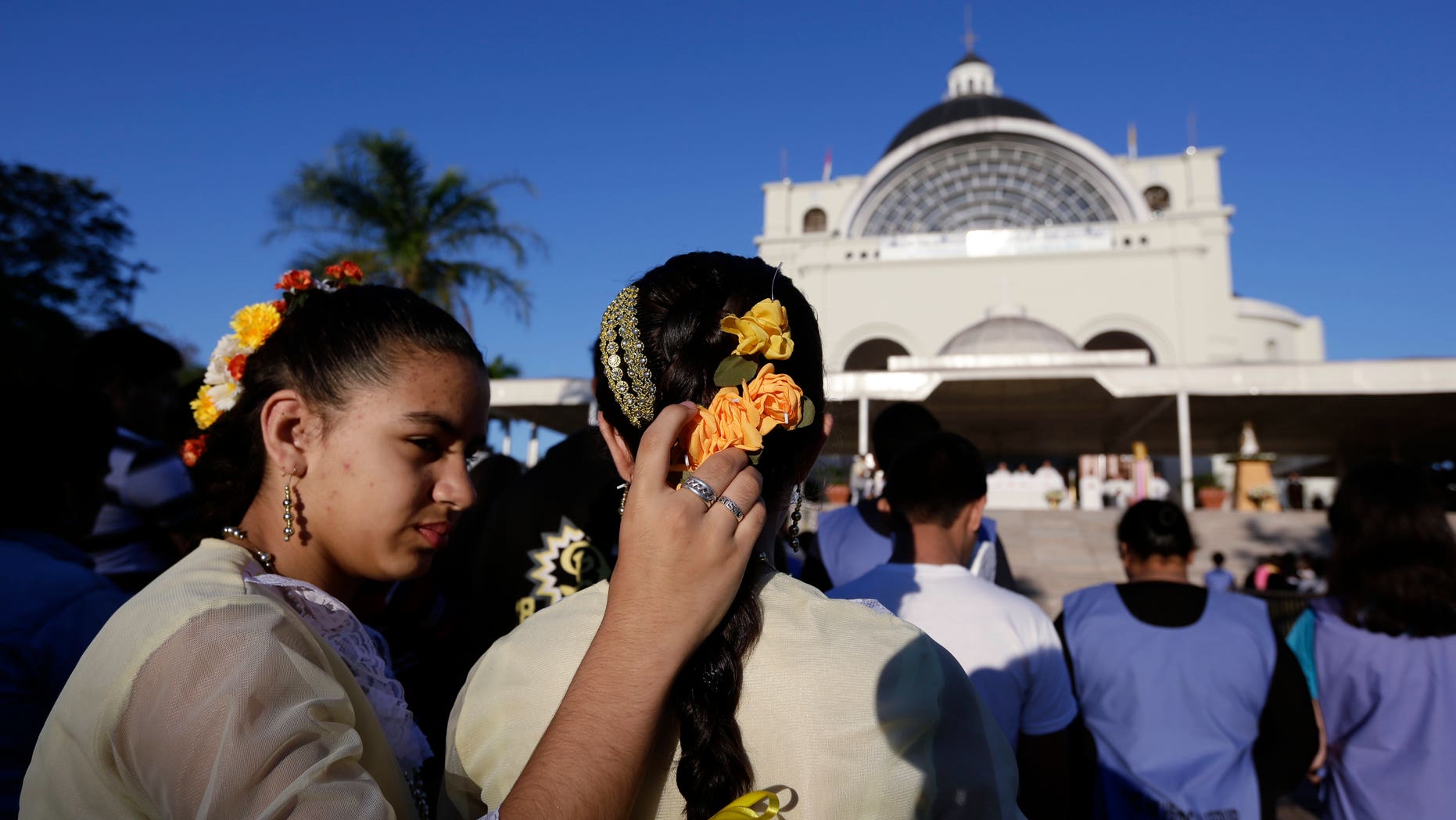 Two sisters during a Corpus Christi mass at shrine of the Virgin of Miracles in Caacupe, Paraguay.