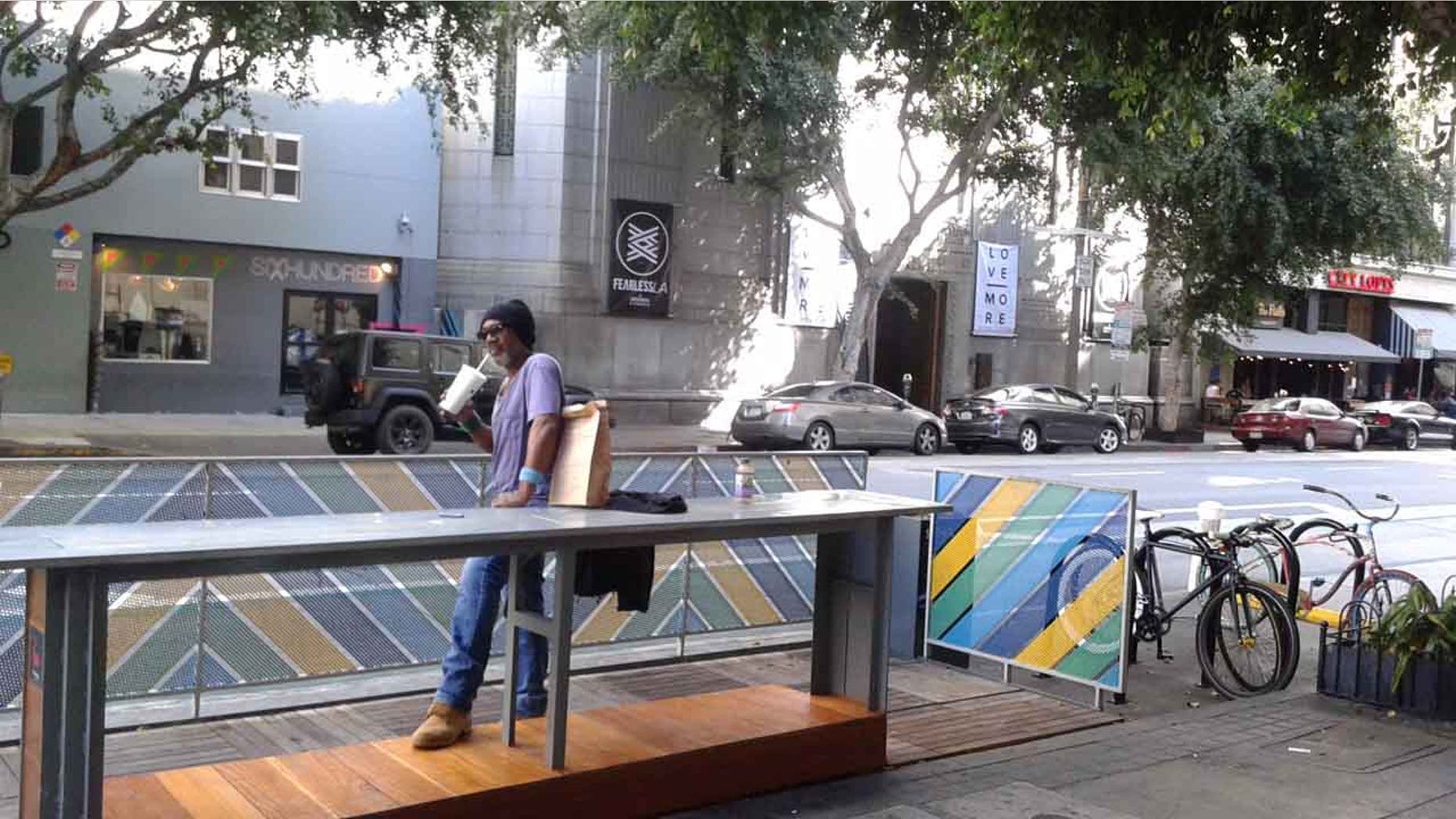A pedestrian stands by a parklet in downtown L.A., California.