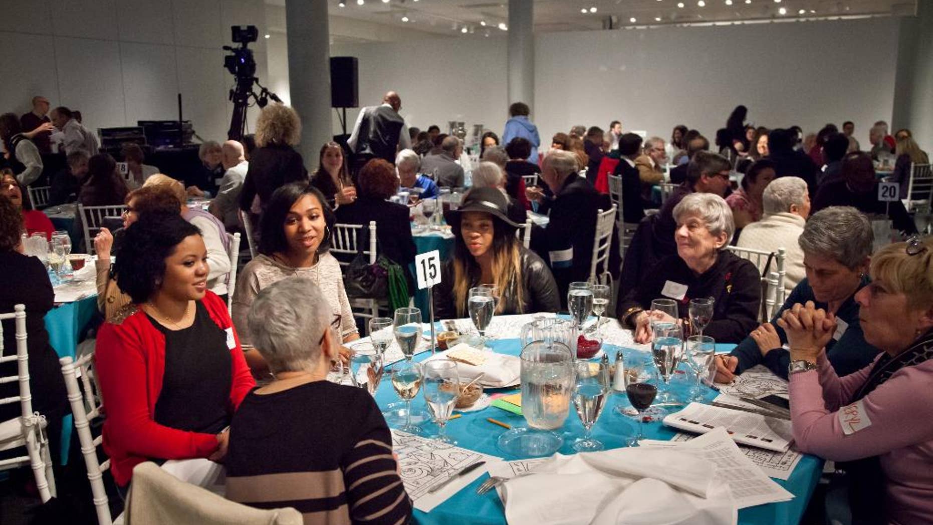 In this Wed., March 25, 2015 photo provided by Matthew Christopher, participants attend Freedom Seder Revisited at the National Museum of American Jewish History in Philadelphia. The event embraces gentiles for an evening of storytelling, music and a taste of traditional Passover food and rituals as it honors the original interfaith Freedom Seder held in 1969 in Washington, D.C., on the first anniversary of Martin Luther King Jr.’s assassination. (AP Photo/Courtesy Matthew Christopher)