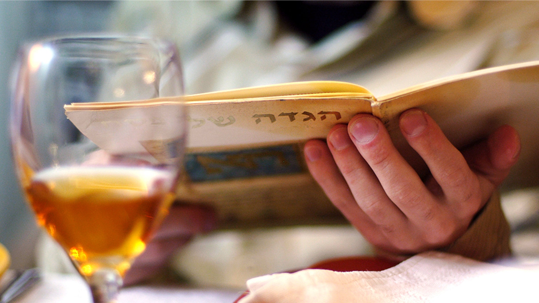 Man reads in the Haggadah book during Passover Seder dinner.