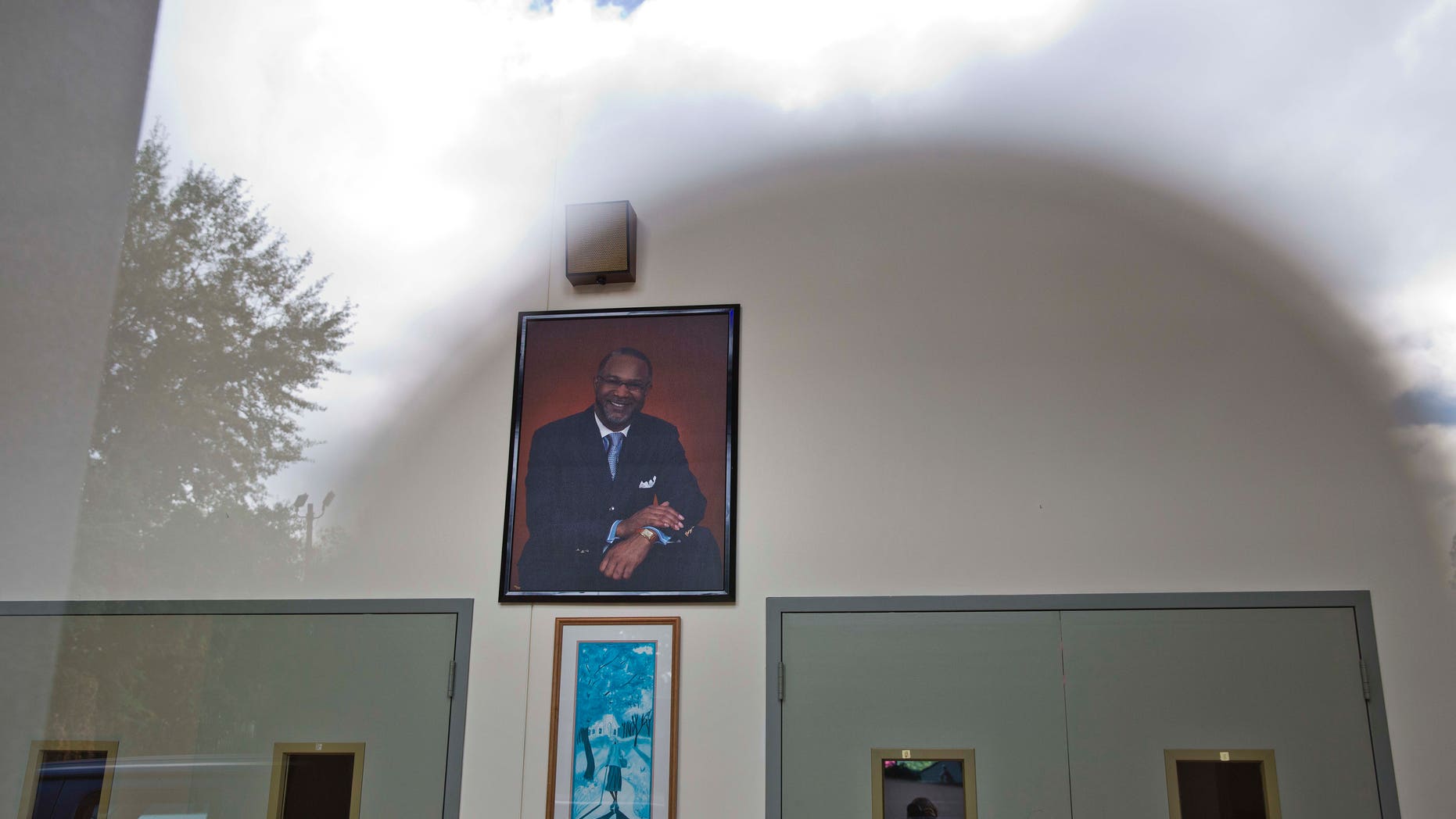 Oct. 14, 2014: The sun and clouds are reflected off a glass on the entrance of the Shiloh Missionary Baptist Church where a portrait of pastor Juan D. McFarland hangs on the wall in Montgomery, Ala. (AP/Brynn Anderson)