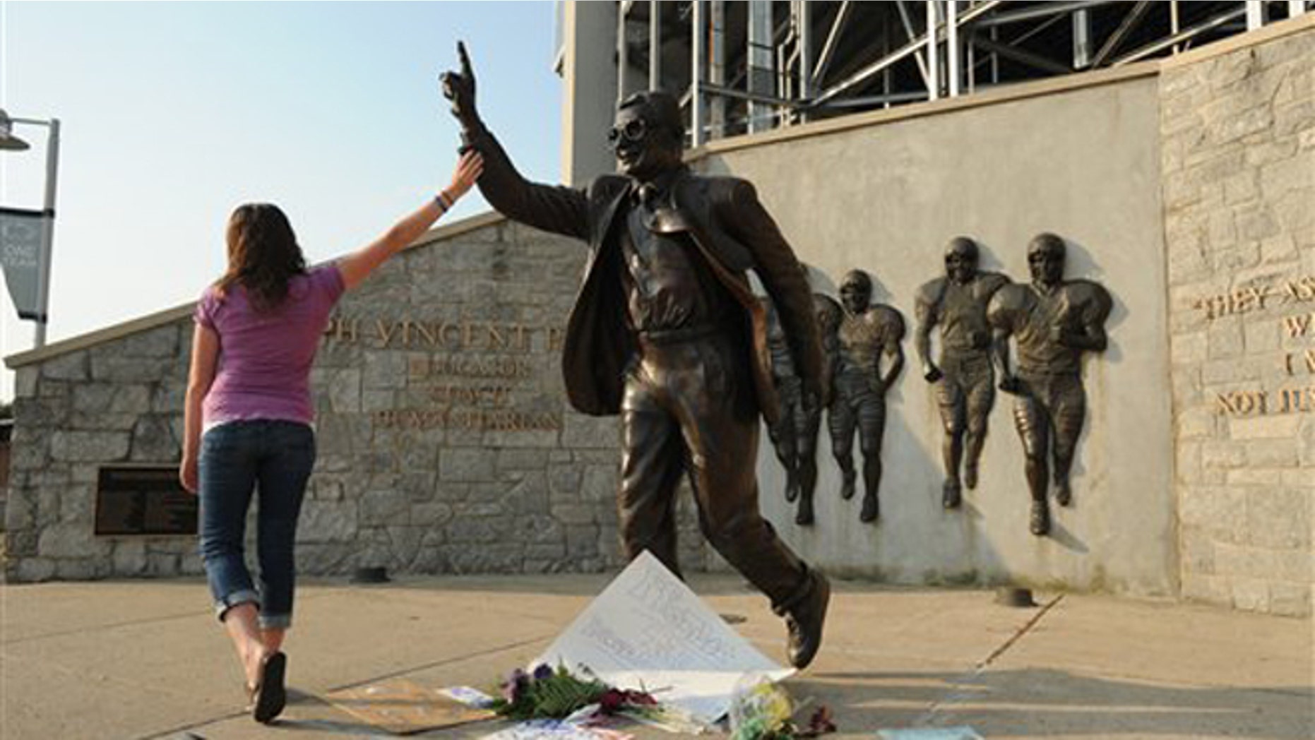 July 18, 2012: Kim Ranck touches the arm on the Joe Paterno statue as she walks away in tears.