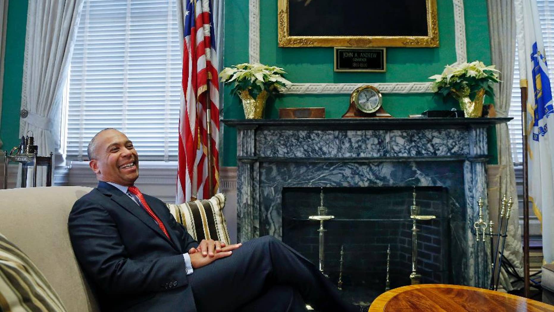 FILE - In this Dec. 15, 2014, file photo, Massachusetts Gov. Deval Patrick speaks during an interview at his Statehouse office in Boston. Patrick has a new job. The former Democratic Massachusetts governor will be joining the Boston firm Bain Capital to develop a line of so-called “social impact" investing to support causes from climate change to hunger. (AP Photo/Elise Amendola, File)
