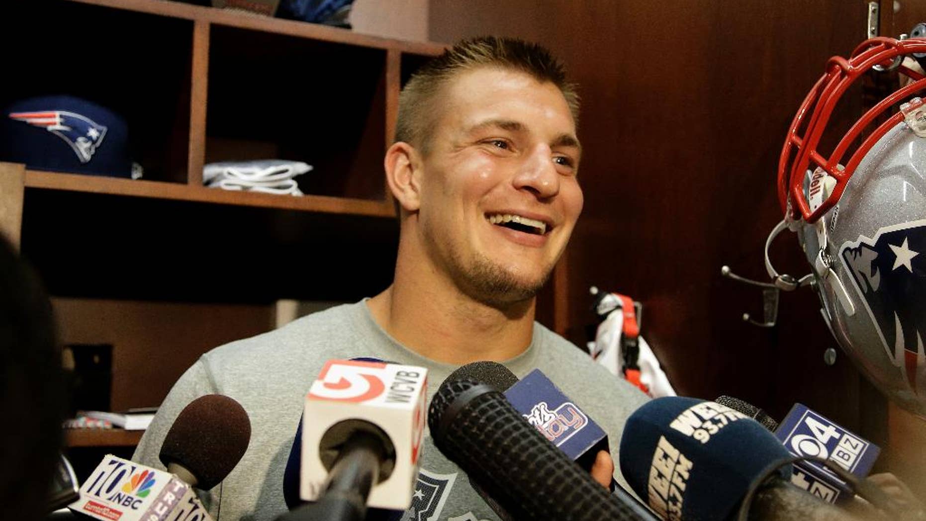 FILE - This Sept. 4, 2013, file photo shows New England Patriots tight end Rob Gronkowski smiling as he talks to the media at the NFL football team's facility in Foxborough, Mass. Gronkowski stood in front of his Gillette Stadium locker Monday, Sept. 1, 2014, and announced he will be playing in the New Patriots' opener at Miami this Sunday. (AP Photo/Stephan Savoia, File)