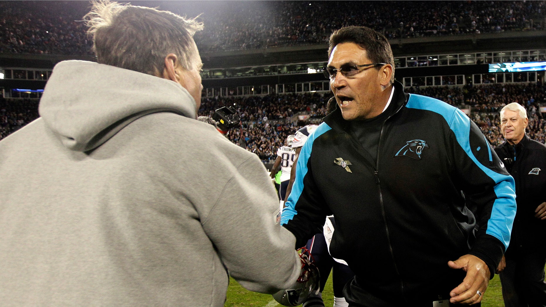 New England Patriots head coach Bill Belichick, left, and Carolina Panthers head coach Ron Rivera shake hands following an NFL football game in Charlotte, N.C., Monday, Nov. 18, 2013. Carolina won 24-20. (AP Photo/Gerry Broome)