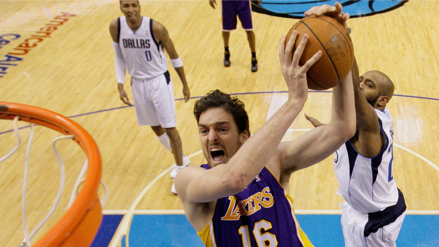 Feb 22: Los Angeles Lakers' Pau Gasol (16) of Spain goes up for a shot as Dallas Mavericks' Vince Carter, right rear. (AP Photo/Tony Gutierrez)