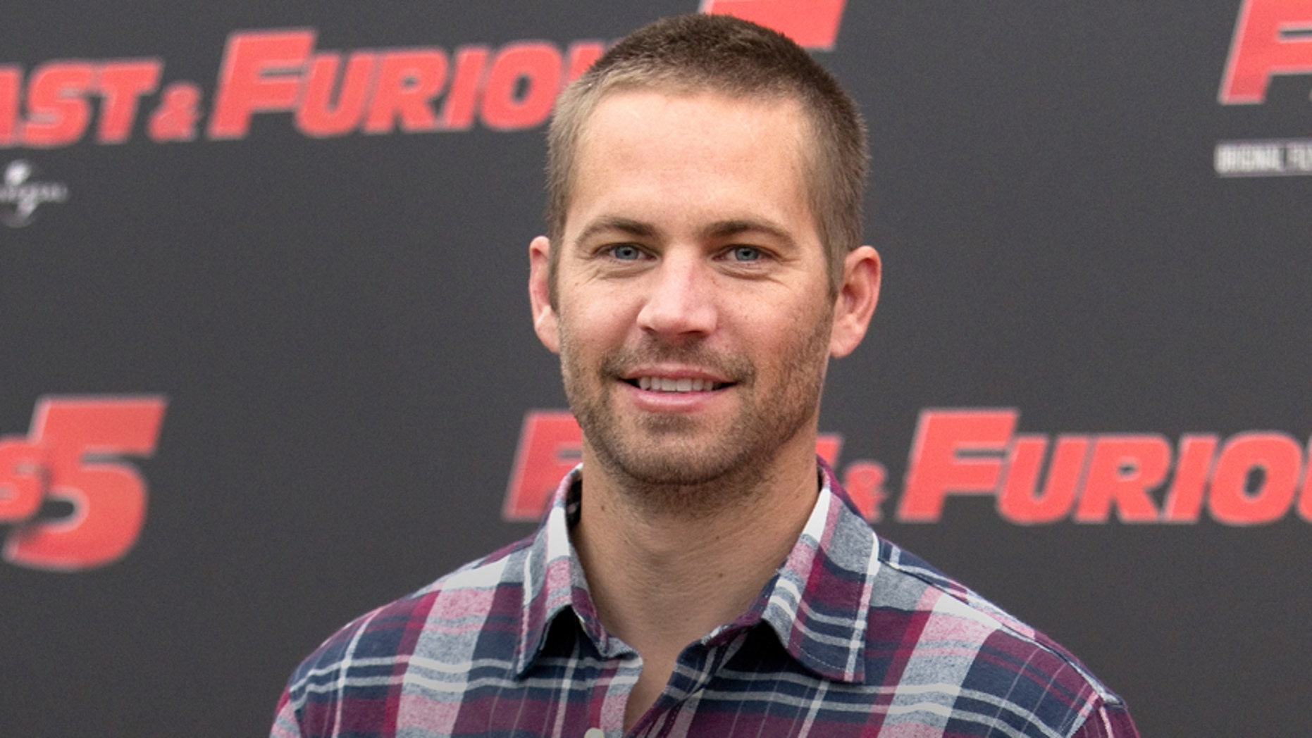 FILE - In this April 29, 2011, file photo, actor Paul Walker poses during the photo call of the movie "Fast and Furious 5," in Rome. Walker's father sued Porsche on Wednesday, Nov. 25, 2015, for wrongful death, claiming the Porsche sports car he was riding in was defective and lacked safety features that might have saved his life during a 2013 crash in Valencia, Calif. (AP Photo/Andrew Medichini, File)