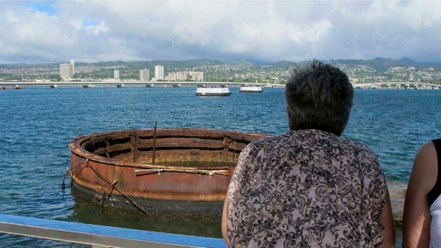 This Nov. 21, 2014 photo shows visitors looking out at the sunken USS Arizona from a memorial atop the rusting battleship in Pearl Harbor, Hawaii. (AP)