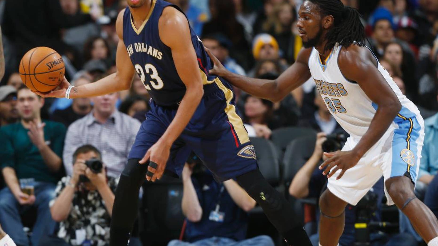 New Orleans Pelicans forward Anthony Davis, left, fields a pass as Denver Nuggets forward Kenneth Faried covers in the first quarter of an NBA basketball game in Denver, Friday, Nov. 21, 2014. (AP Photo/David Zalubowski)