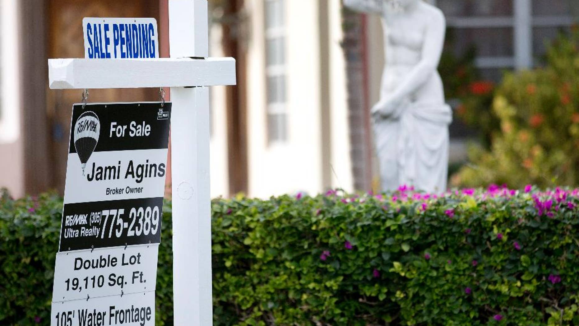 In this Thursday, Jan. 8, 2015 photo, a "sale pending" placcard is placed atop a realty sign outside a home for sale in Surfside, Fla. More Americans signed contracts to buy homes in February, the National Association of Realtors reported Monday, March 30, 2015, evidence that the spring buying season could open strong after sluggish sales for much of the winter. (AP Photo/Wilfredo Lee)