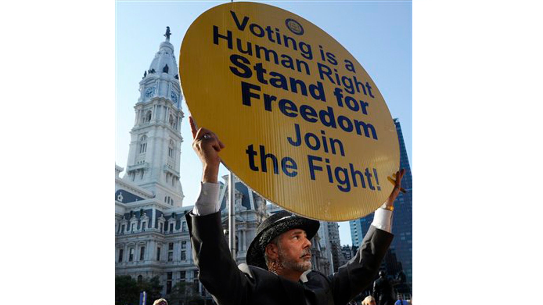 Jay Kohn, of Morristown, NJ, holds a sign during the NAACP voter ID rally to demonstrate the opposition of Pennsylvania's new voter identification law, Thursday, Sept. 13, 2012, in Philadelphia. Pennsylvania's Supreme Court justices are scheduled to hear arguments over whether a new law requiring each voter to show valid photo identification poses an unnecessary threat to the right to vote. (AP Photo/Michael Perez)