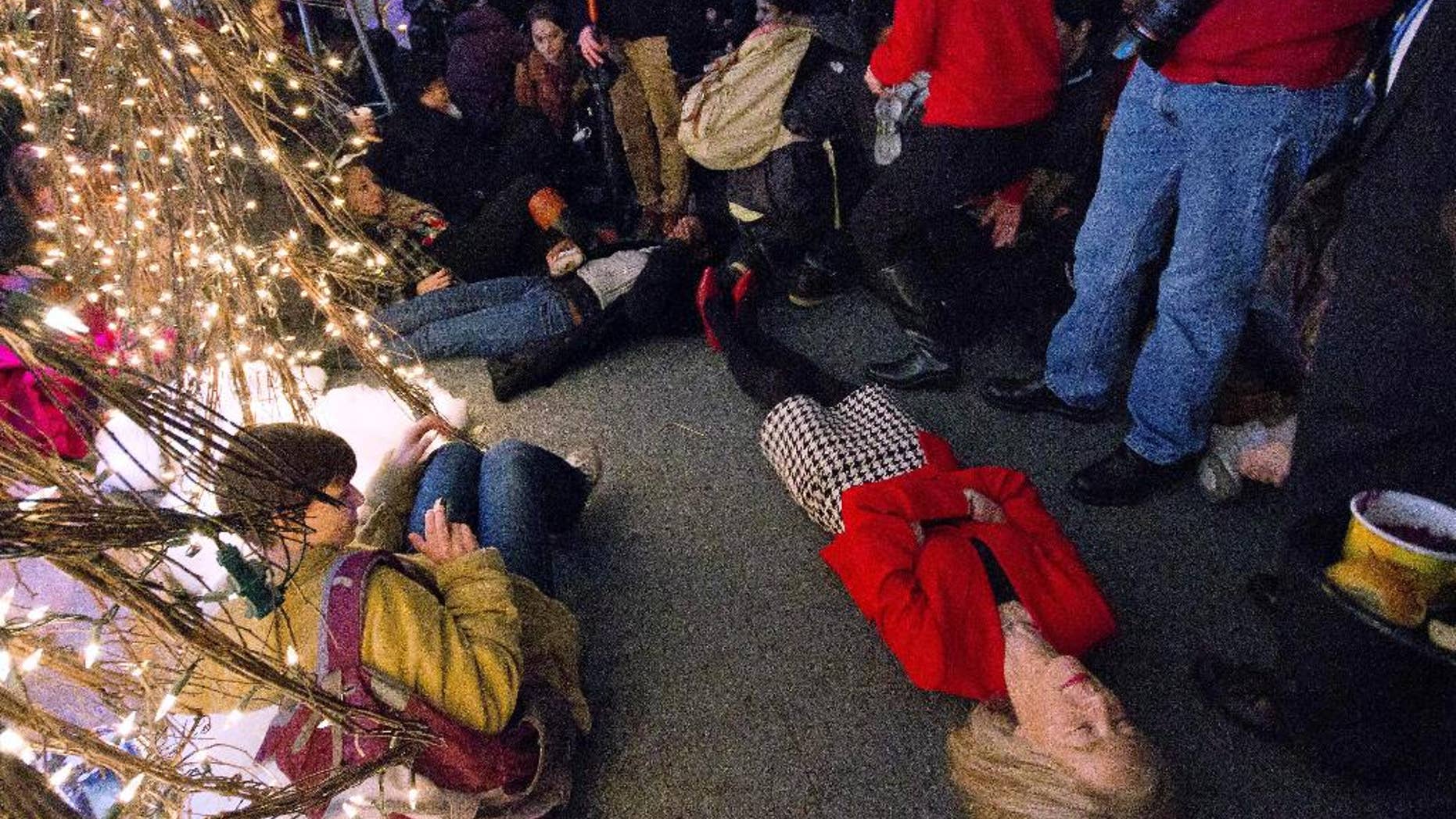 In this Tuesday, Dec. 9, 2014 photo provided by The Daily Pennsylvanian, University of Pennsylvania President Amy Gutmann joins protesters at a holiday party at her home in Philadelphia, lying on the floor for a symbolic 4½ minute "die-in" to protest the police-shooting death of Michael Brown in Ferguson, Mo. The head of the campus police union said officers were outraged by Gutmann's display after student protesters interrupted her holiday party. A Penn vice president said Guttmann was showing solidarity with students, not attacking officers. (AP Photo/The Daily Pennsylvanian, Luke Chen)