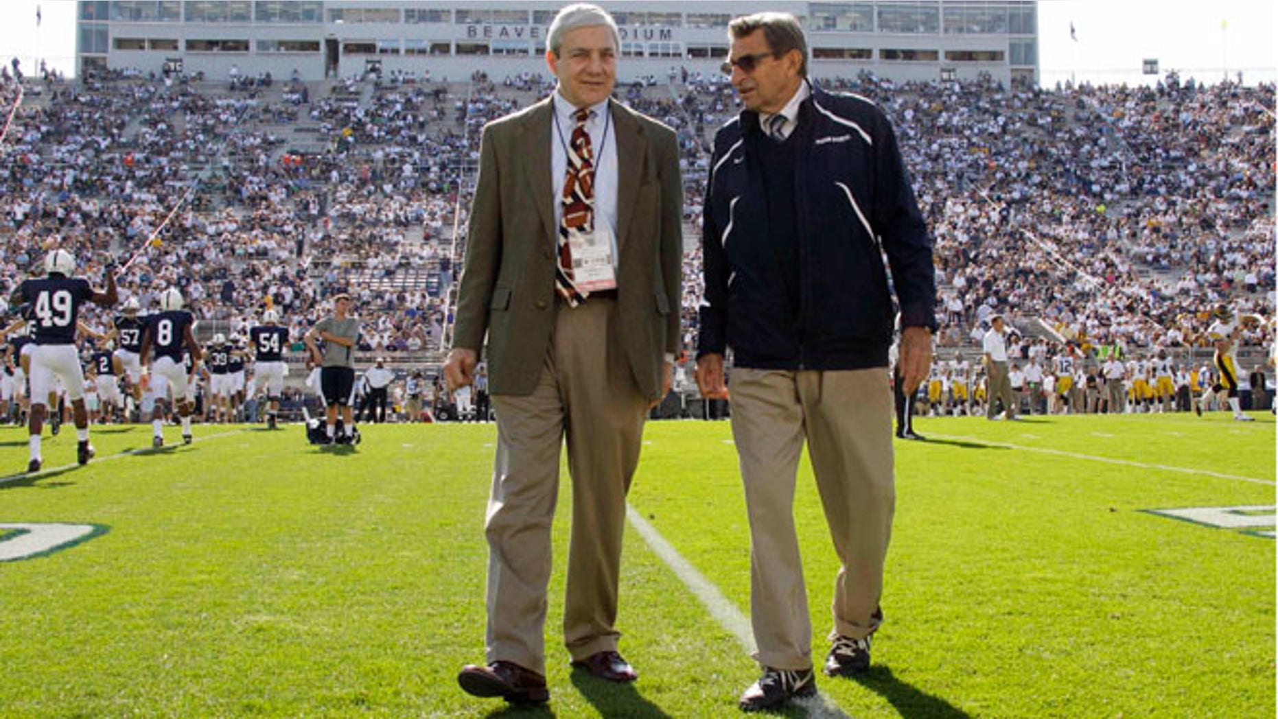 Oct. 8, 2011: This file photo Penn State president Graham Spanier, left, and head football coach Joe Paterno chat before an NCAA college football game against Iowa in State College, Pa.