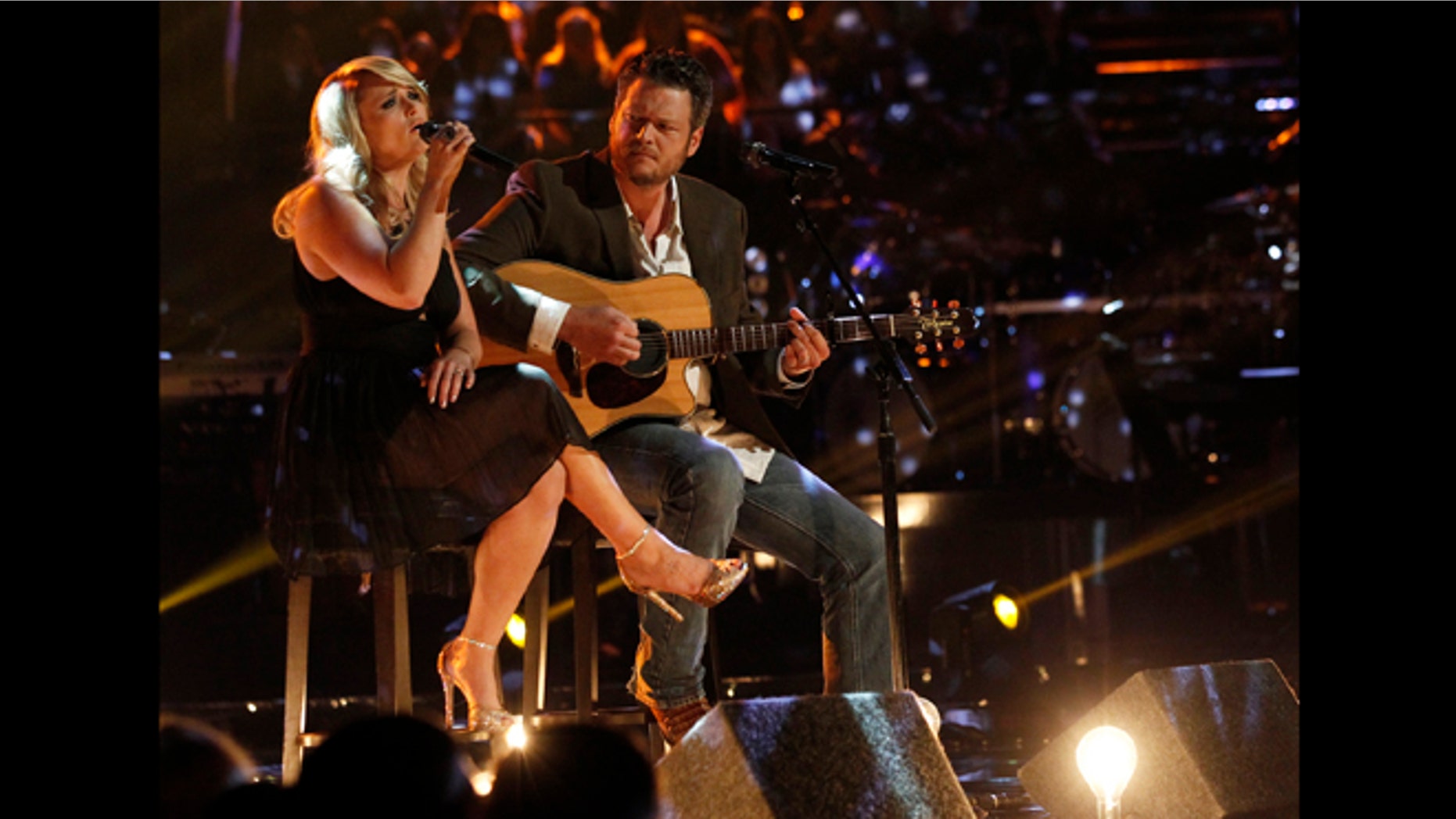 This May 21, 2013 photo released by NBC shows married singers Miranda Lambert, left, and Blake Shelton performing an acoustic version of the hit "Over You" during a broadcast of the singing competition series, "The Voice," in Los Angeles.