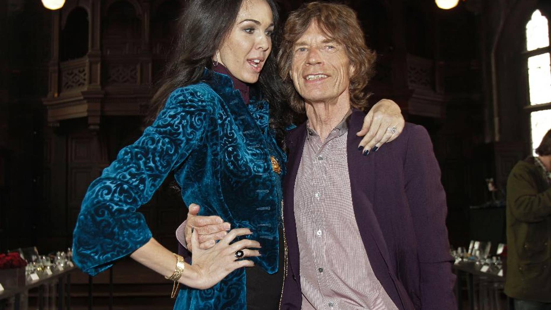 FILE - This Feb. 16, 2012 file photo shows singer Mick Jagger, right, with designer L'Wren Scott after her Fall 2012 collection was modeled during Fashion Week, in New York. Jagger has established a scholarship in honor of his late girlfriend, fashion designer Scott. The scholarship will allow one master’s degree student per year over a period of three years to attend the elite Central Saint Martins, the London-based college announced this weekend. (AP Photo/Richard Drew, File)