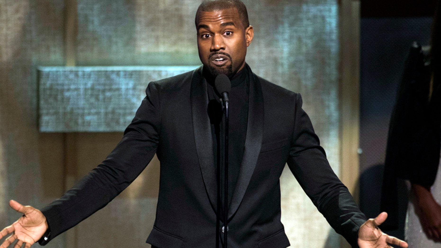 FILE - In this Jan. 24, 2015, file photo, BET Honoree Kanye West accepts the Visonary Award at the BET Honors 2015 at Warner Theater in Washington. West on Tuesday, April 7, 2015, settled a lawsuit filed by a paparazzo who the rapper attacked outside a Los Angeles International Airport terminal in 2013. Daniel Ramos' attorney Gloria Allred wrote in a statement that the suit was settled in part after West apologized to her client and the pair shook hands. (Photo by Kevin Wolf/Invision/AP, File)