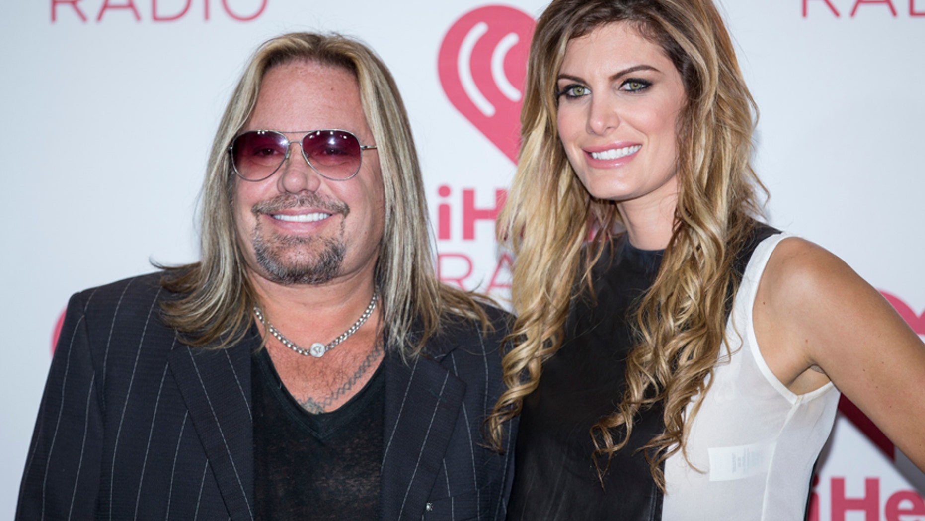 In this Sept. 19, 2014 file photo, Vince Neil and girlfriend Rain Andreani arrive at the iHeart Radio Music Festival, at The MGM Grand Garden Arena in Las Vegas.