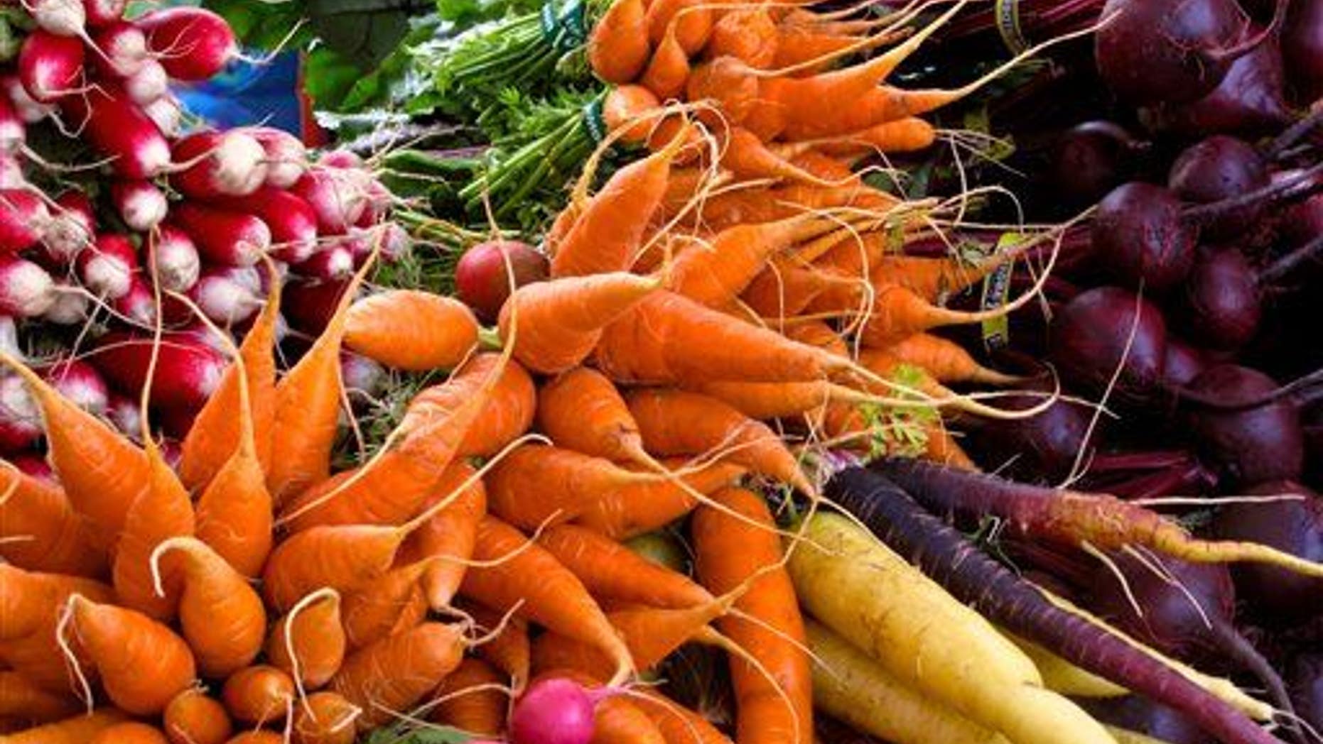 This photo taken on Oct. 5, 2013, shows radishes, carrots, turnips, and beets at a farmers market near Langley, Wash.