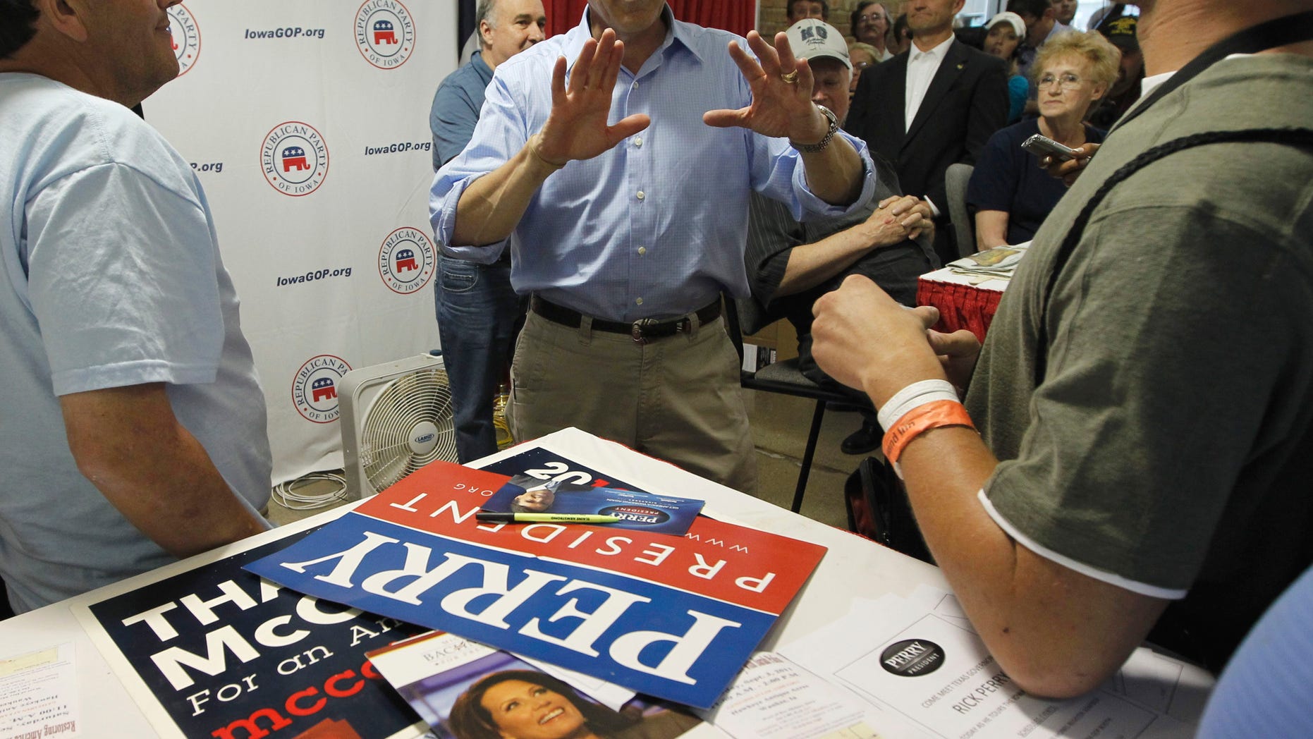 August 15: Flyers for Rep. Michele Bachmann, R-Minn. and former Alaska Gov. Sarah Palin can be seen on the table as Republican presidential candidate, Texas Gov. Rick Perry visits the Iowa GOP Booth at the Iowa State Fair in Des Moines.