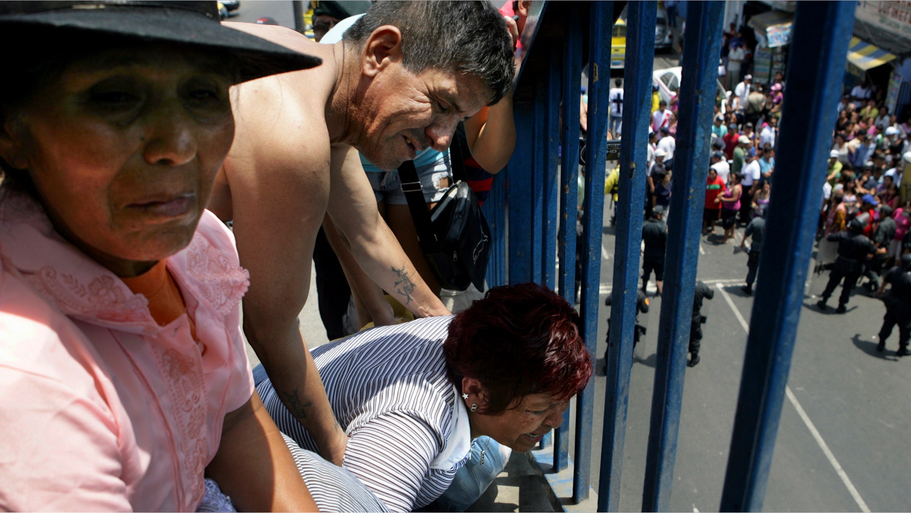 Relatives of patients of the "Christ is Love" center for drug and alcohol addicts, react in Lima, Peru, Saturday, Jan. 28, 2012. A fire swept through the private rehabilitation center for Saturday, killing at least 26 people and injuring 10 as firefighters punched holes through walls to rescue residents trapped inside. (AP Photo/Juan Contreras)